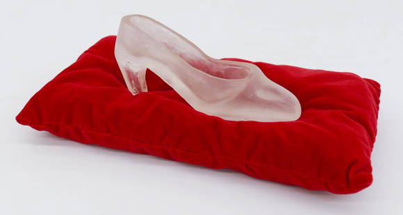 Silvia Levenson (b.1957 American) ''Cenerentola'': Silvia Levenson (b.1957 American) ''Cenerentola'' (Cinderella) 1998 Kiln Cast Glass with Fabric Pillow 4.5''x14.5''x8''. Clear cast glass slipper 8'' with cast tack on inside. It sits on a red velvet