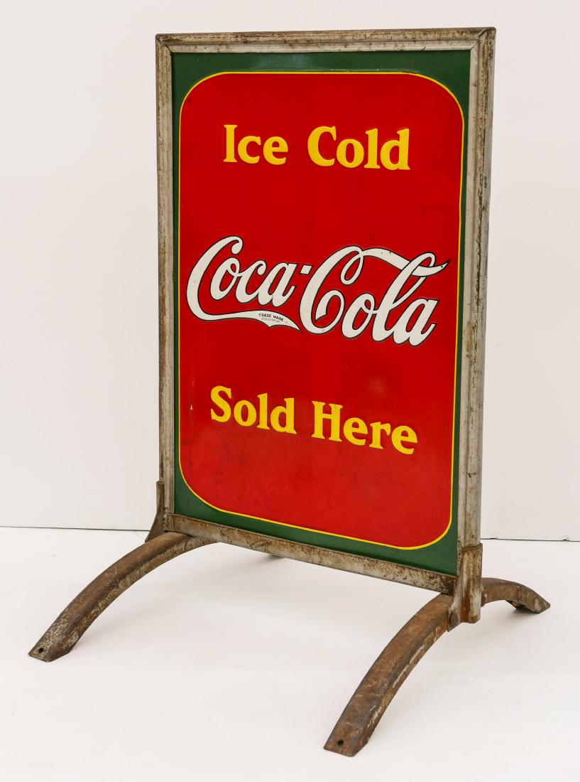 1938 Coca-Cola Double Sided Tin Sidewalk Sign: 1938 Coca-Cola Double Sided Tin Sidewalk Sign 32''x20''x22''. A colorful tin standing signed that reads ''Ice Cold Coca Cola Sold Here''. Original steel standard. One side has an area of over cleaning