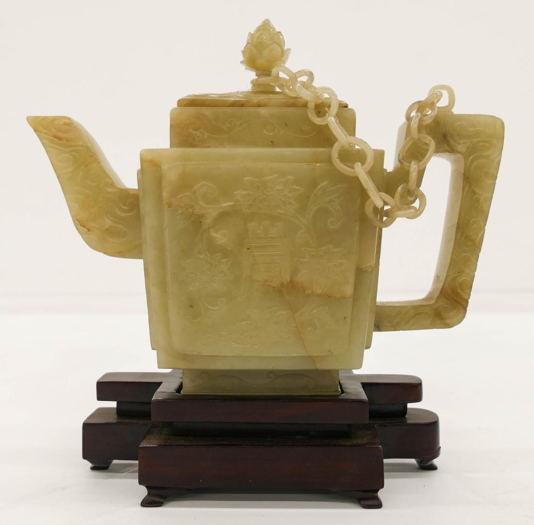 Fine Chinese Jade Teapot on Stand 7''x7.5''. An: Fine Chinese Jade Teapot on Stand 7''x7.5''. An intricately carved pale celadon jade teapot with relief lotus flower and calligraphy motif. Figural lotus flower finial and carved ring chain. Fitted ro