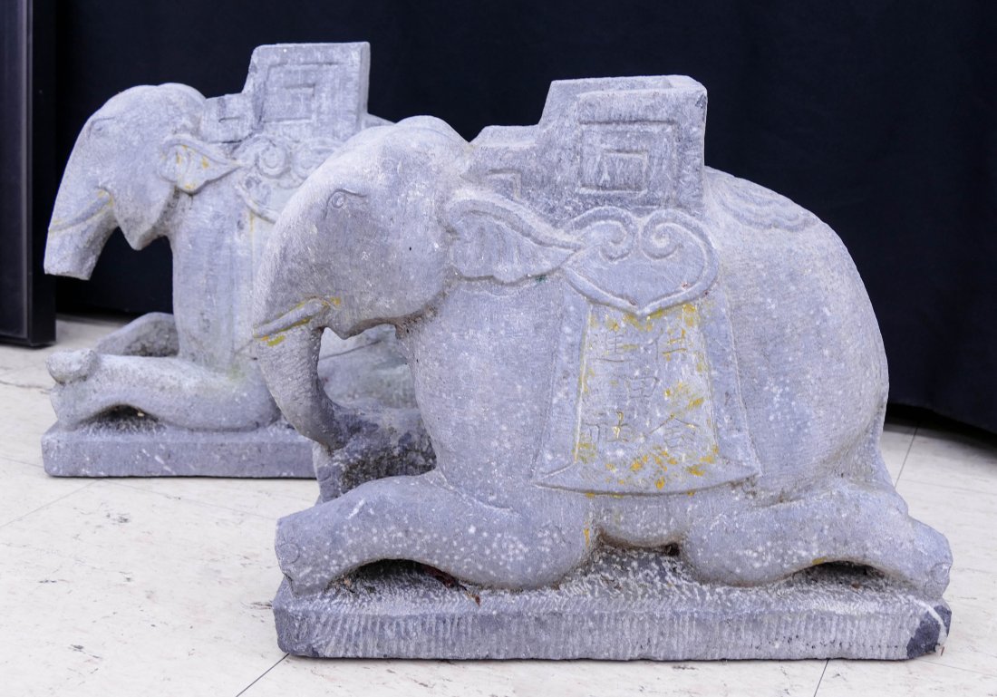 Pair Vietnamese Stone Elephant Statues 14"x17" Each. A: Pair Vietnamese Stone Elephant Statues 14"x17" Each. A solid pair of carveds tone elephant temple figures with saddles and calligraphy. One is missing part of his trunk. Some scattered edge chipping f