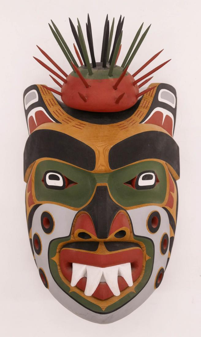 Tony Hunt Jr. (1961-2017 Kwakiutl) Komokwa Mask 1988: Tony Hunt Jr. (1961-2017 Kwakiutl) Komokwa Mask 1988 Cedar 17''x10''x9''. Carved and painted native two part mask with sea urchin applied top. Signed and titled on verso. One break to spike on urchin.