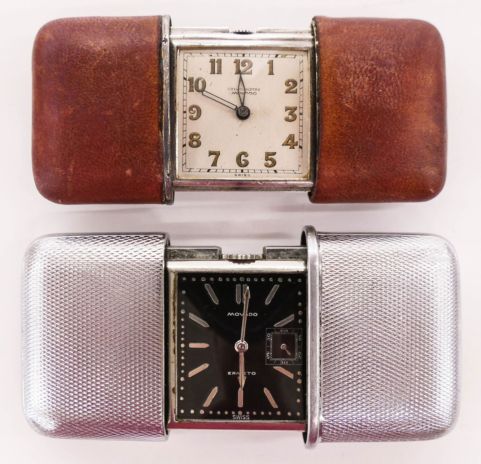 2pc Vintage Movado Ermeto & Chronometre Travel Clocks.: 2pc Vintage Movado Ermeto & Chronometre Travel Clocks. Includes a brown leather Movado Chronometre folding clock with a .935 silver case serial number 1190228. Also a black dial Ermeto in stainless ca