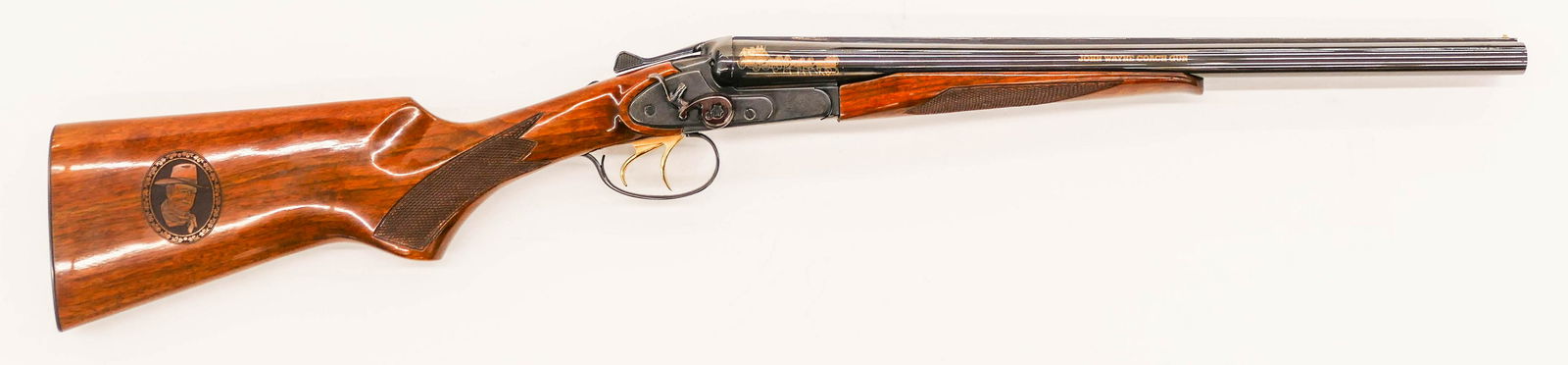 John Wayne Commemorative Coach Gun Double Barrel: John Wayne Commemorative Coach Gun Double Barrel Shotgun 35''. A gold inlaid 12 gauge shotgun with 19'' barrel. Manufactured by Baikal and presented by American Remembers, United States Society of Arm