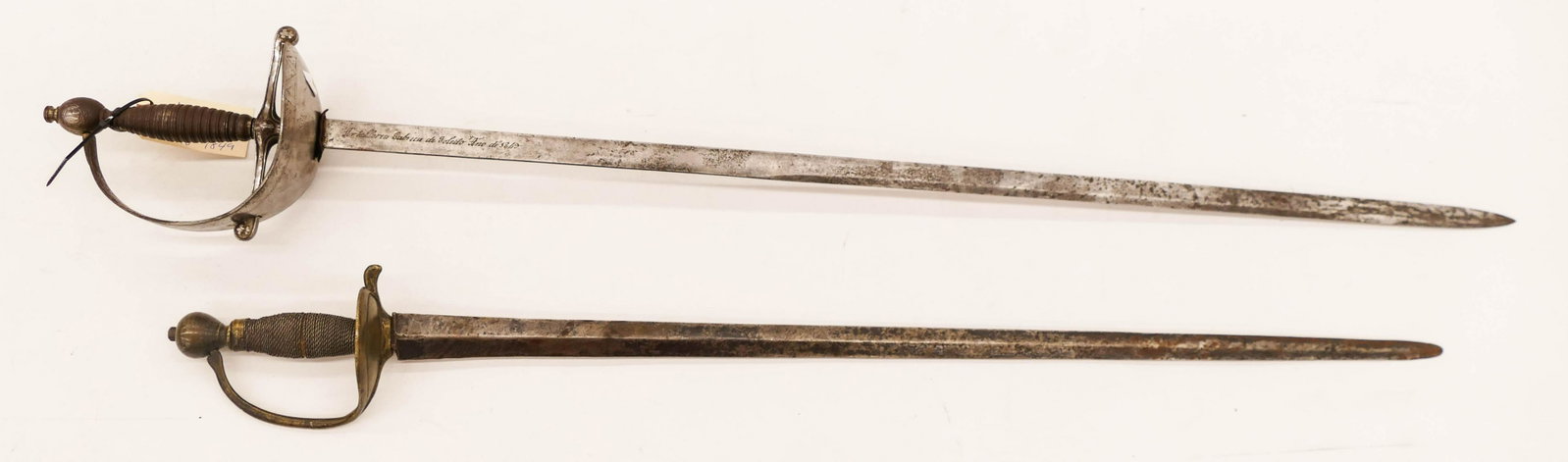 2pc Antique European Swords 33'' and 38''. Includes an: 2pc Antique European Swords 33'' and 38''. Includes an early short sword with brass guard and wire wrapped handle. Also an Alabardero Kings Guard Spain 1849 sword. Missing scabbards with scattered wea