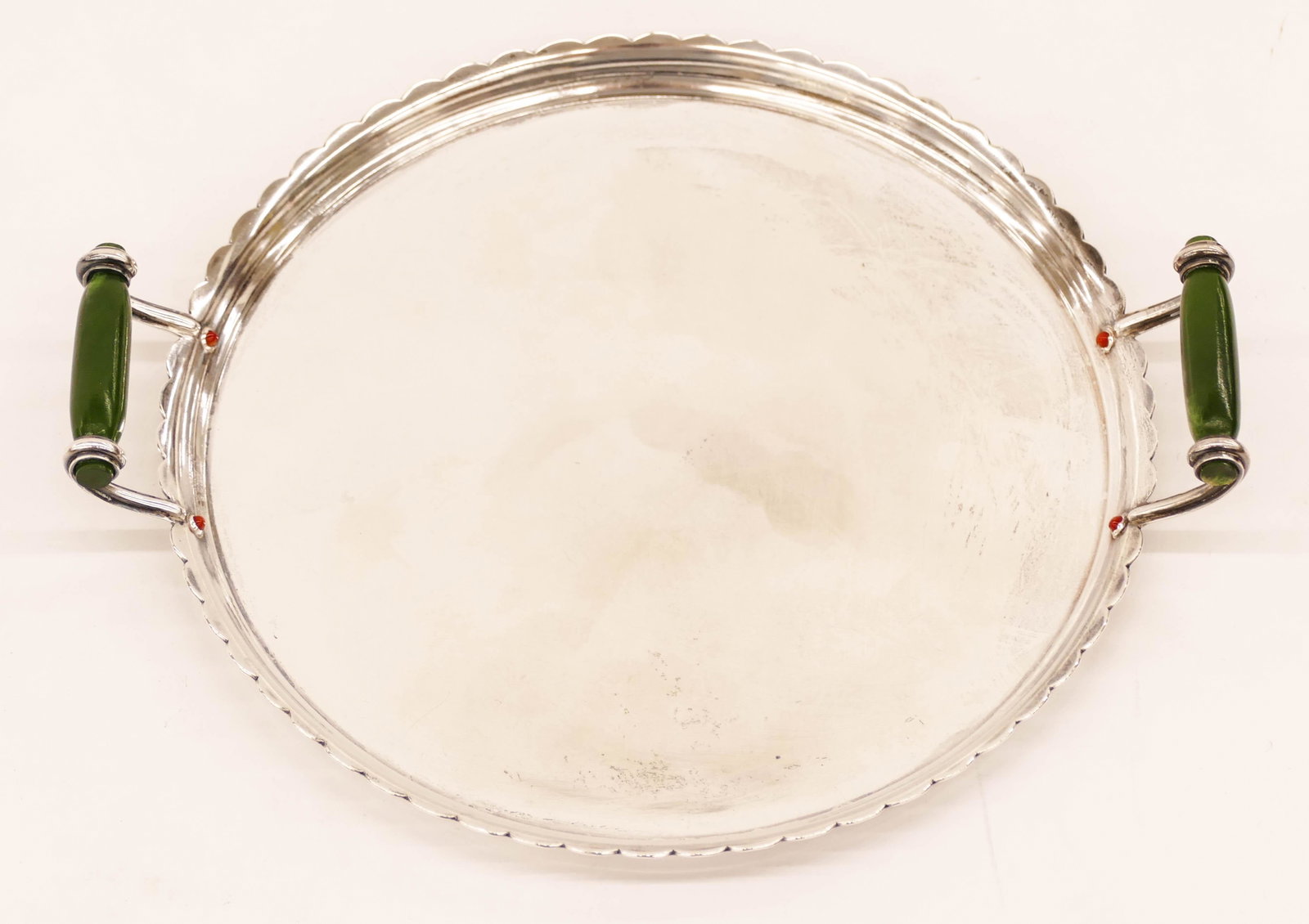 Cartier Art Deco Sterling Jade Handled Small Tray: Cartier Art Deco Sterling Jade Handled Small Tray 7''x8''. A French art deco round cocktail tray with carved jade handles and red coral beading. Marked on side. Monogrammed ''O.J.G.'' on verso. It wei