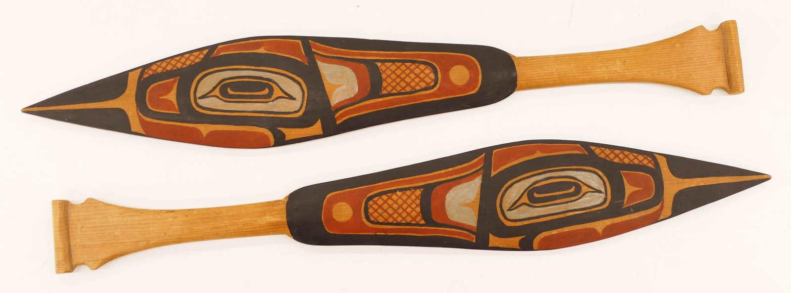 Pair of 1920's Northwest Coast Native Paddle Models: Pair of 1920's Northwest Coast Native Paddle Models 17''x2.75'' Each. A pair of polychrome u-form painted and carved cedar miniature paddles. One is marked ''Sitka 1927''. Some slight surface wear. Ov