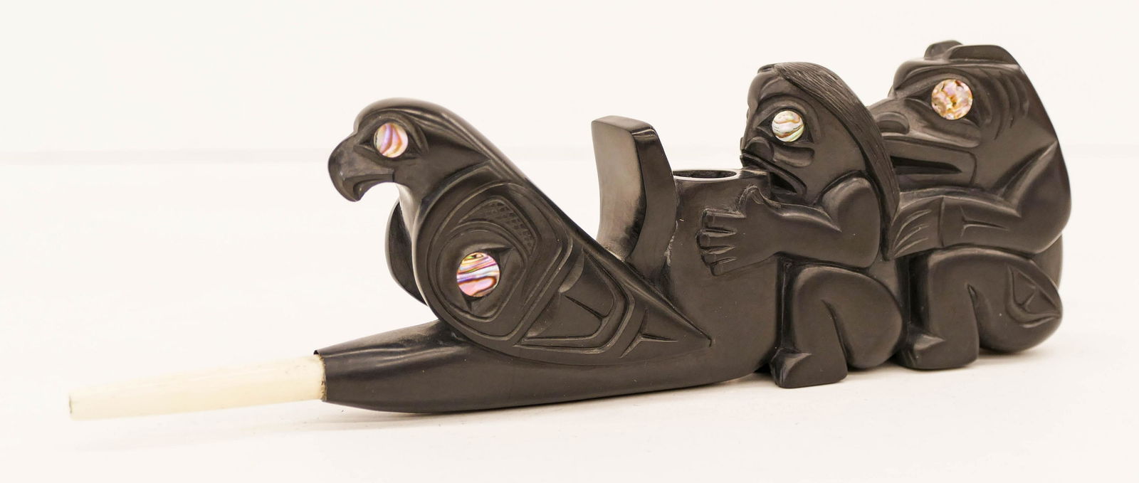 Glen Pollard (b.1957 Haida) Bear Human Eagle 1987: Glen Pollard (b.1957 Haida) Bear Human Eagle 1987 Argillite Pipe 2.5''x7.5''. Impressive Northwest Coast native carved figural pipe with inlaid abalone shell eyes. Signed and dated on bottom. Excellen