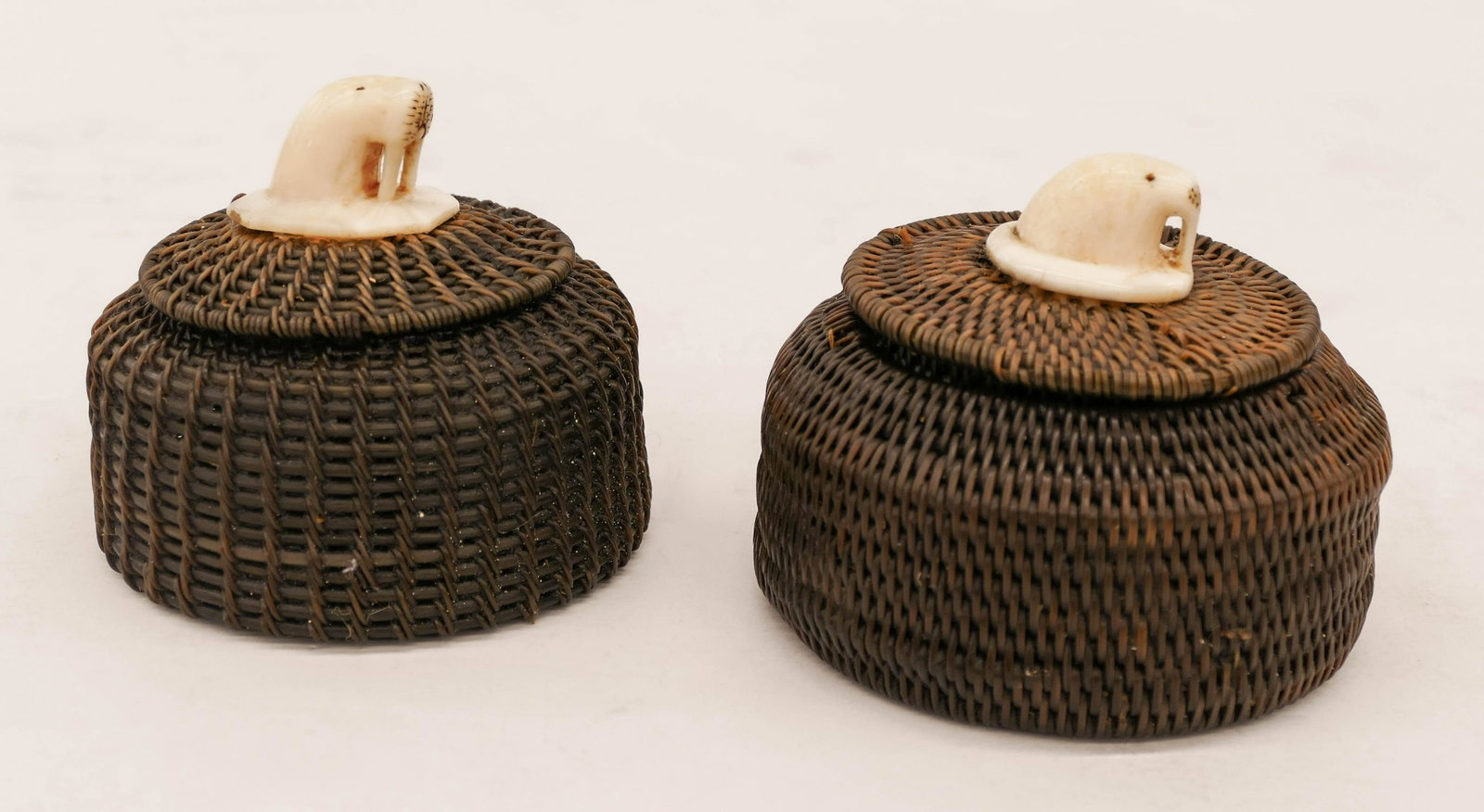 2pc Old Inuit Native Baleen Baskets 3''x3.5'' Each: 2pc Old Inuit Native Baleen Baskets 3''x3.5'' Each Approx. An old duo of woven covered baskets with carved walrus head finials. Unsigned. Shorter basket has several small breaks to weave. Overall exce