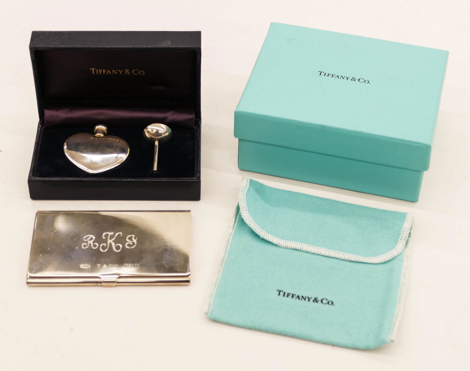 2pc Tiffany & Co. Sterling Perfume and Card Case in: 2pc Tiffany & Co. Sterling Perfume and Card Case in Boxes. Includes a heart shaped perfume bottle with funnel 1.75'' and a business card case 2.25''x3.75'' (monogrammed RKG). Clearly marked with boxes