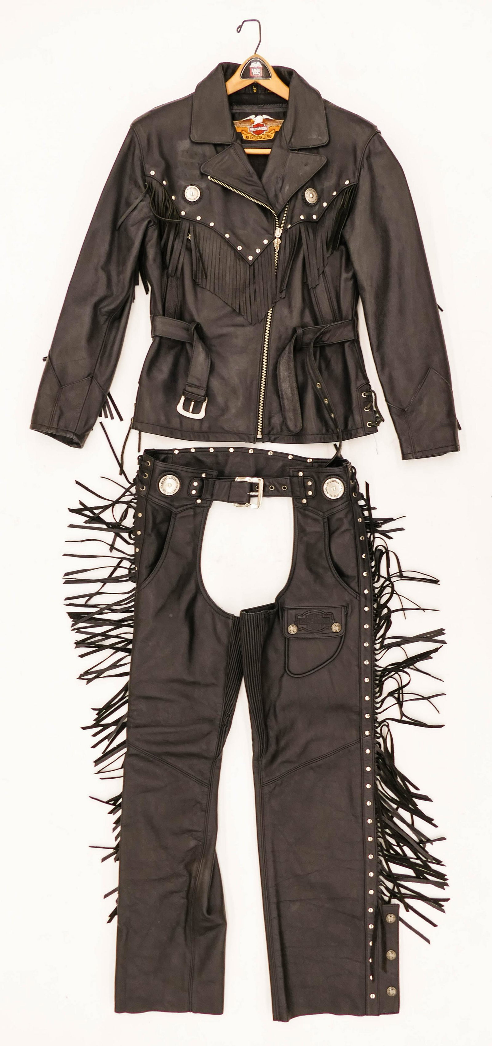 2pc Women's Harley Davidson Black Leather Motorcycle: 2pc Women's Harley Davidson Black Leather Motorcycle Riding Outfit Size Large. Includes a fringe jacket with buttons and matching chaps. Light wear from use.