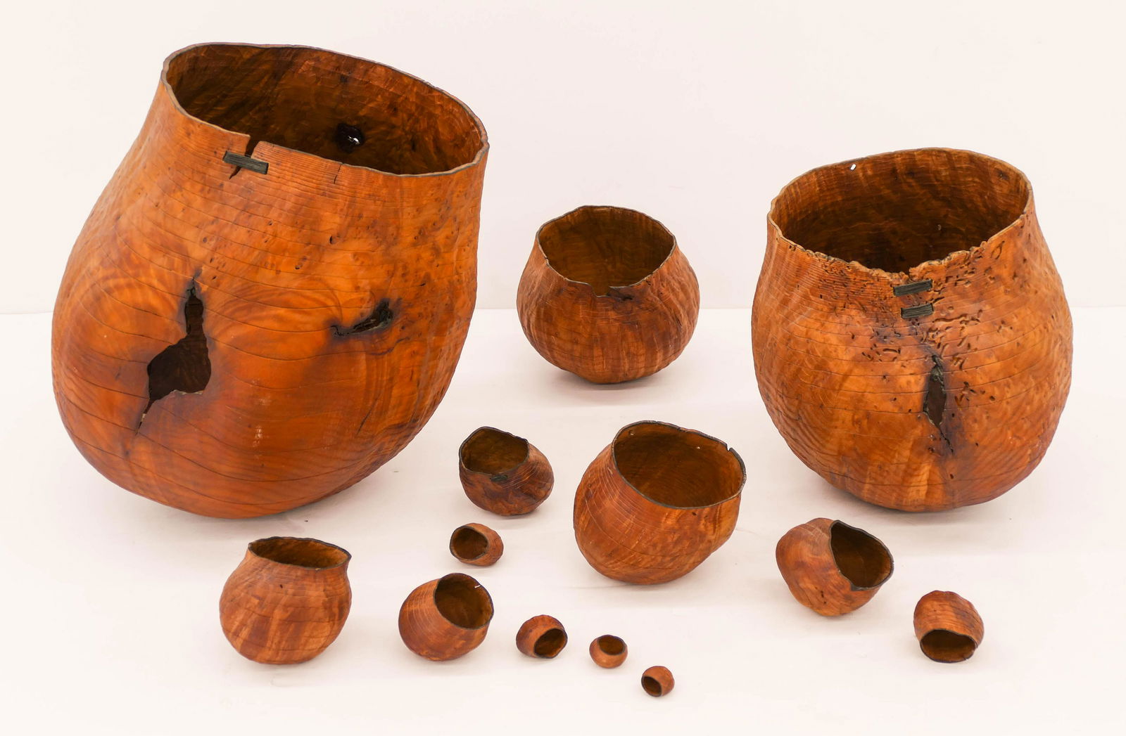 Christian Burchard (b.1955 Oregon) 13-Piece Madrone: Christian Burchard (b.1955 Oregon) 13-Piece Madrone Burl 1999 Basket Set 15''x13''. A turned wood and carved nesting basket set with linen mends. Each piece is signed or initialed on bottom. Smallest