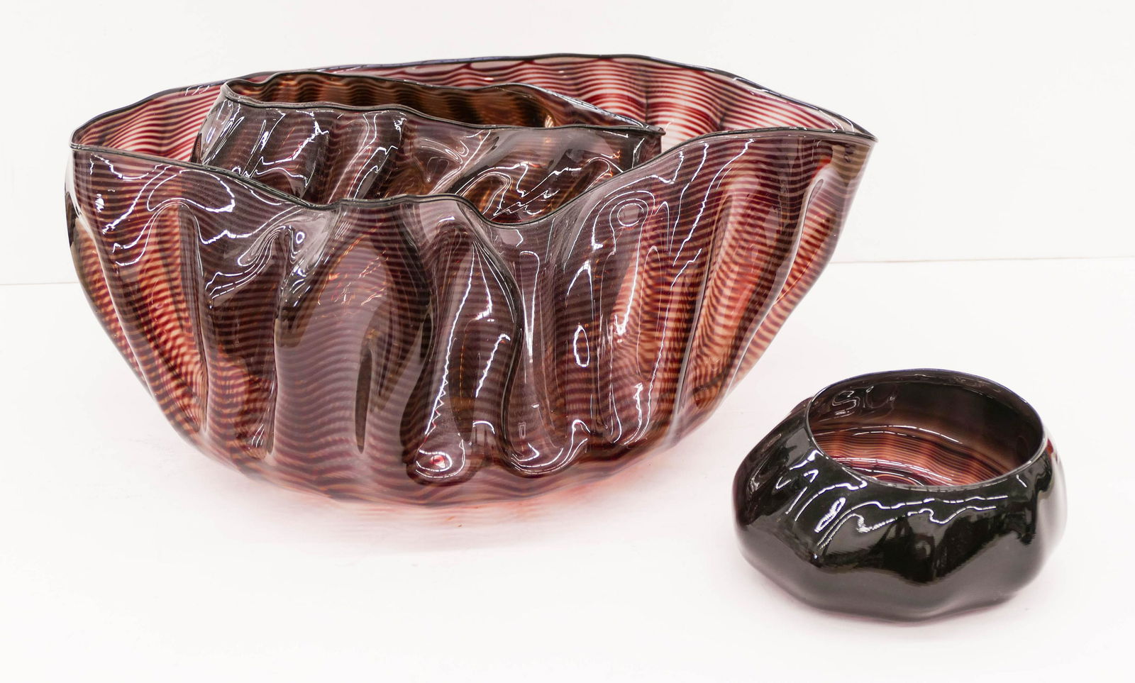 Dale Chihuly (b.1941 Washington) 3-Piece Mahogany: Dale Chihuly (b.1941 Washington) 3-Piece Mahogany Seaform Set 1981 Blown Glass 7''x16''x14.5''. A three piece free form nesting glass set with ebony lip wrap. Smallest piece measures 3''x6''. All thre