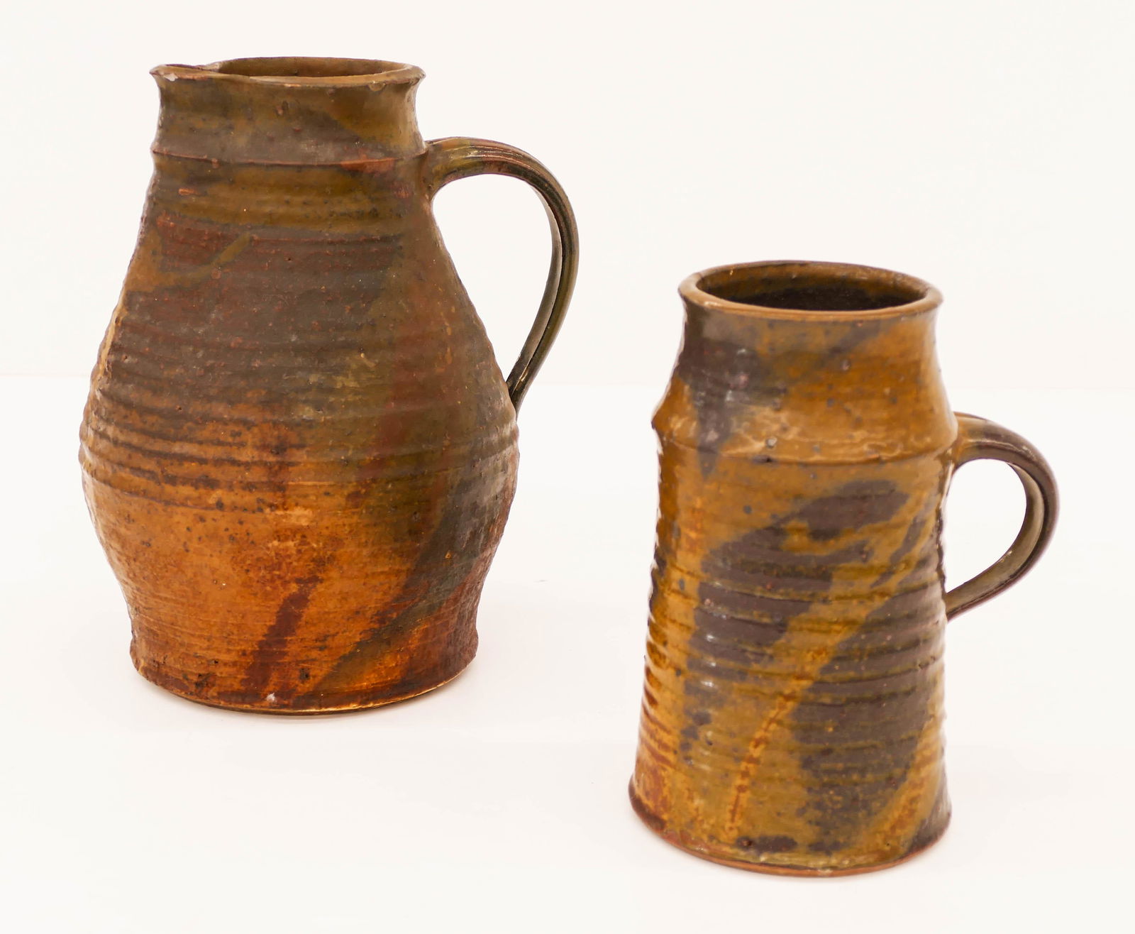 2pc Howard Kottler (1930-1989 Washington) Stoneware: 2pc Howard Kottler (1930-1989 Washington) Stoneware Pitcher and Mug 1960. Includes a wheel thrown and speckled glaze pitcher 9.25'' and a mug or tankard 7.25''. Marked on bottom. Mug has glaze pop on