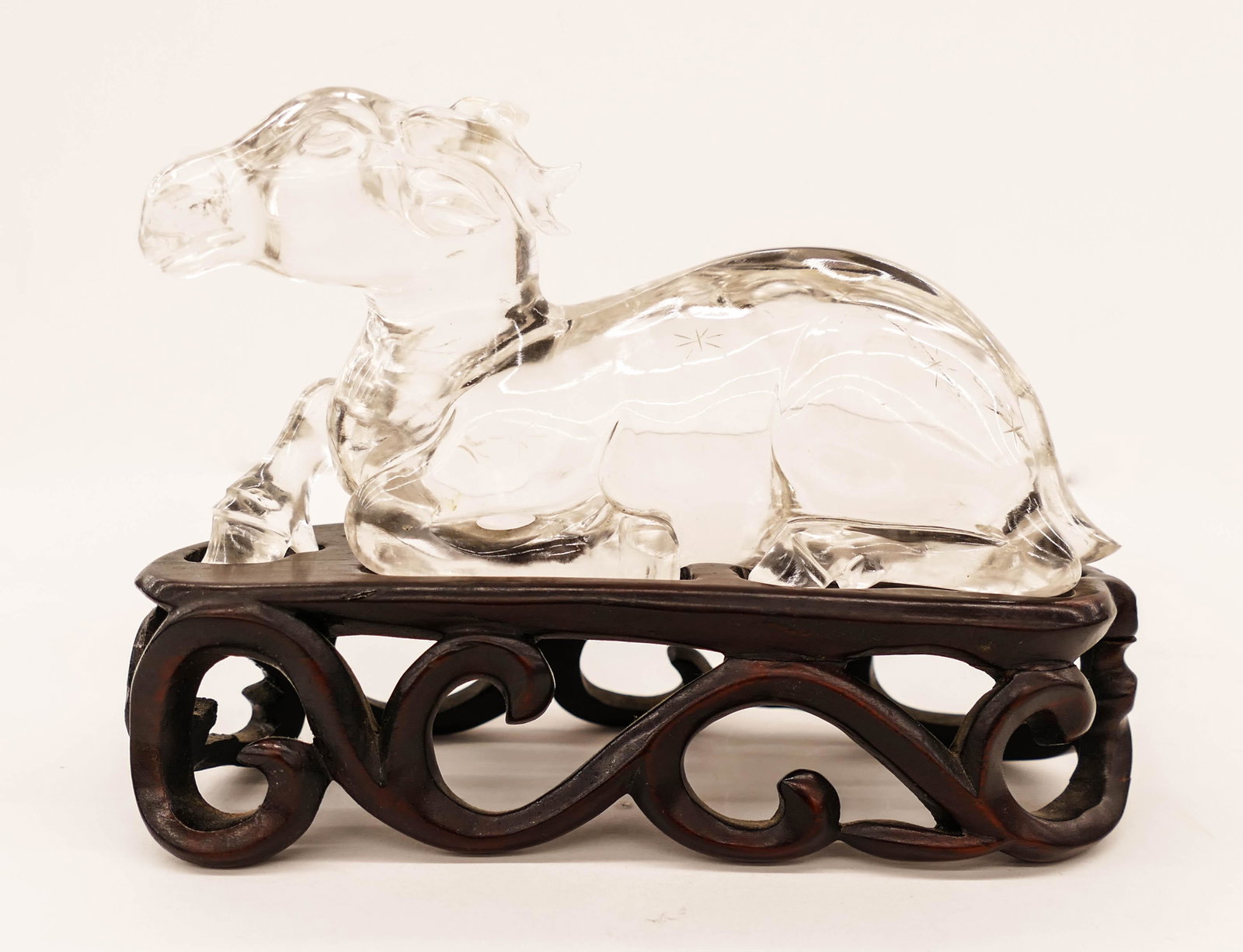 Old Chinese Rock Crystal Deer on Stand 4''x6''. A: Old Chinese Rock Crystal Deer on Stand 4''x6''. A carved clear quartz figure of a reclining deer. Carved rosewood fitted stand. One tiny chip to edge of tail. Early 20th century, late Qing or Republic