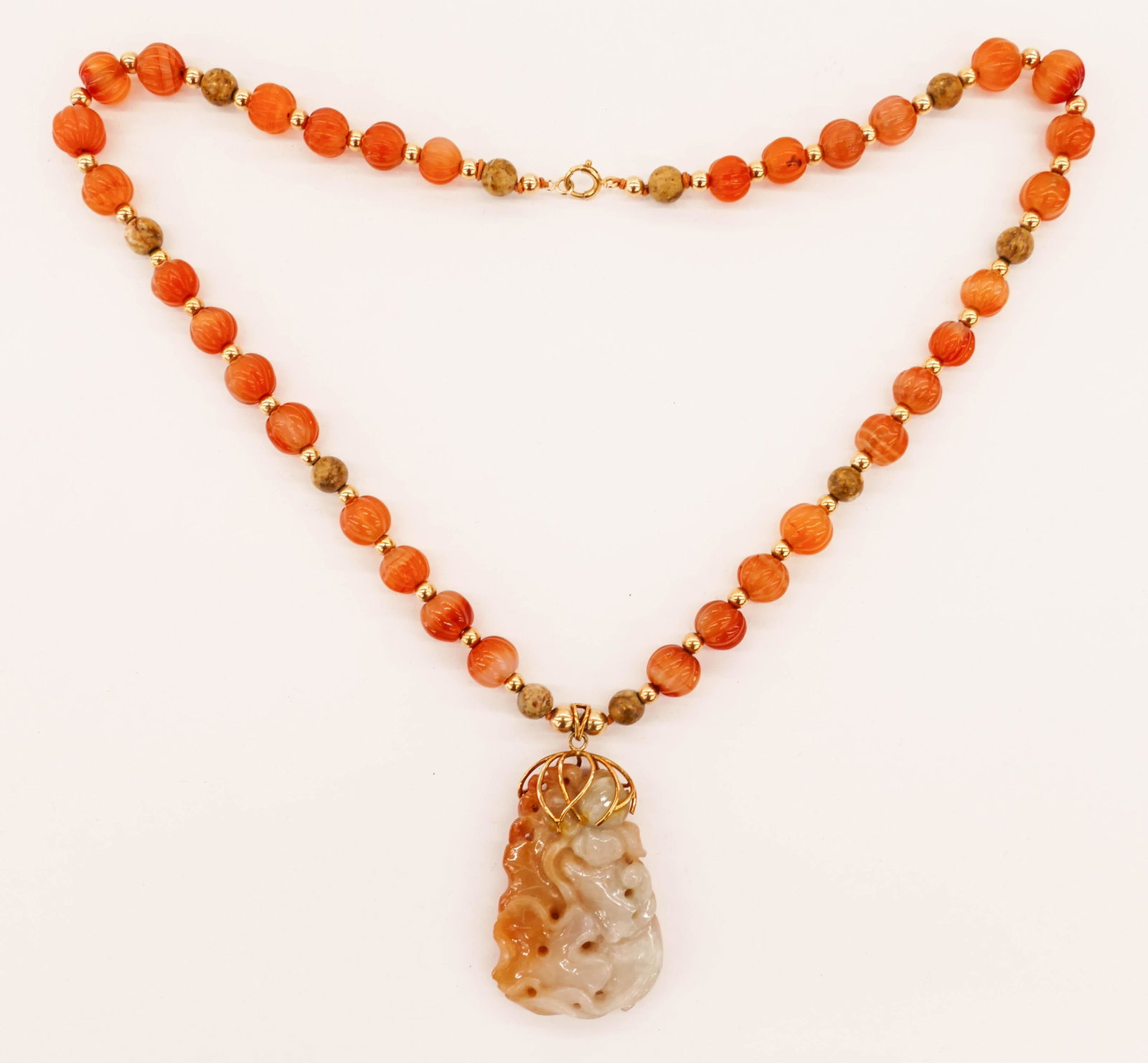 Chinese 14k Carnelian and Jade Pendant Necklace 22''.: Chinese 14k Carnelian and Jade Pendant Necklace 22''. Includes a 14k mounted russet to white jade carp and lotus pendant 2.25''x1.5''. It is suspended by 11mm carved carnelian melon beads with 5mm gol