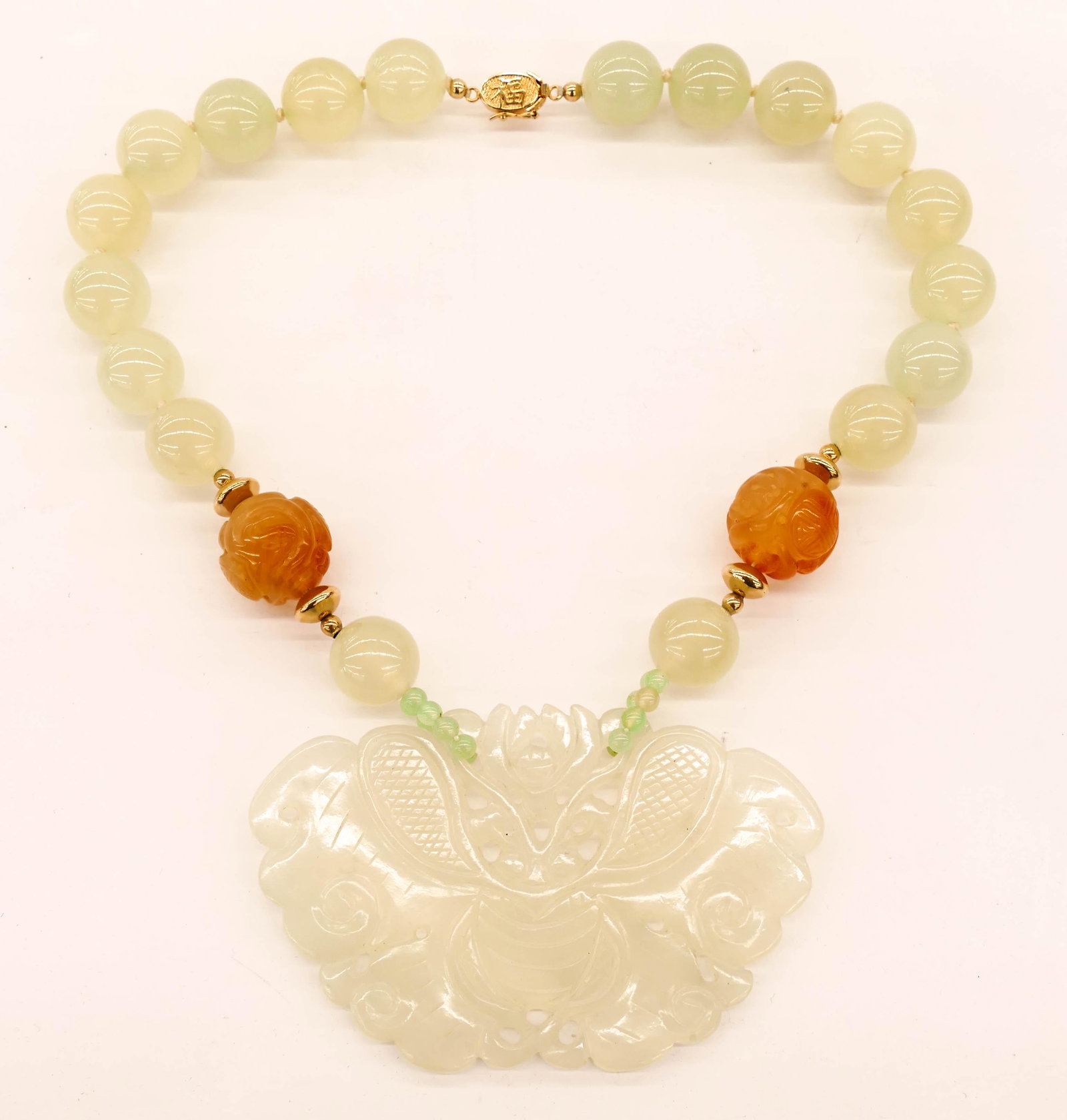 Chinese Jade Moth Large Pendant Necklace 16''. Includes: Chinese Jade Moth Large Pendant Necklace 16''. Includes a large translucent carved jade pierced pendant 2.5''x4'' suspended from translucent 16mm jade and 21mm carnelian shou beads. Gold washed silver