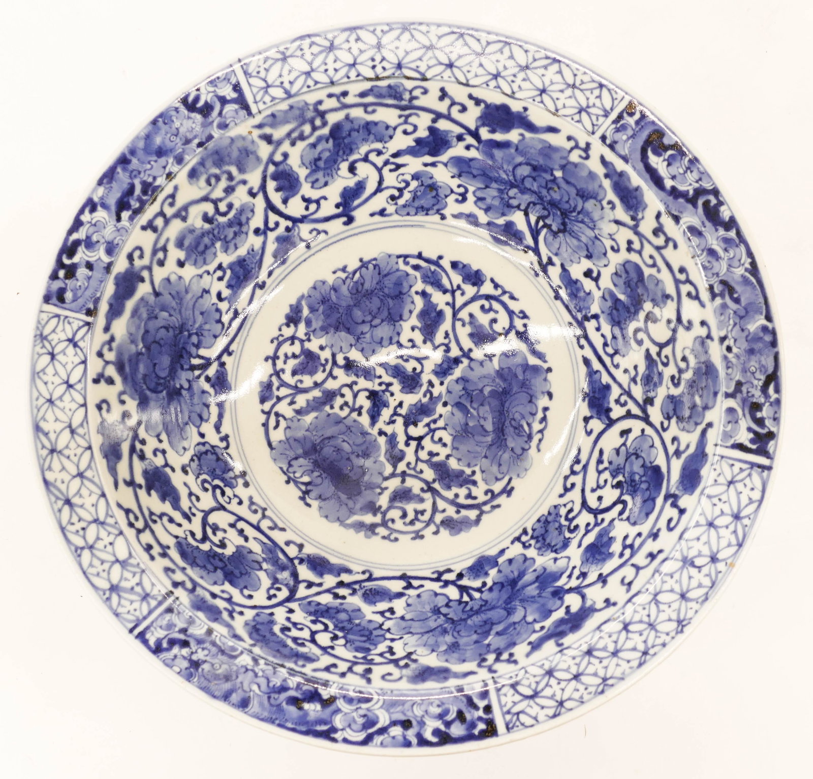 Japanese Edo Arita Porcelain Large Bowl 16''x5.75''. A: Japanese Edo Arita Porcelain Large Bowl 16''x5.75''. A blue and white underglaze decorated scrolling flower bowl. Unmarked. Excellent condition with no damage. Bowl has bowed in firing. 18th or 19th c