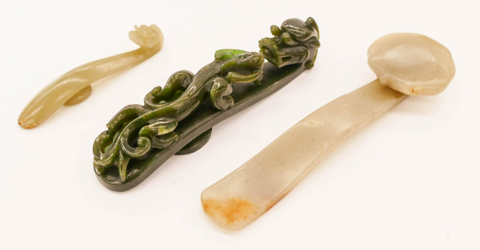 3pc Chinese Jade Belt Hooks and Ruyi Scepter 3'' to: 3pc Chinese Jade Belt Hooks and Ruyi Scepter 3'' to 5.5'' Long. Includes a spinach jade dragon belt hook, a pale celadon with slight russet splash belt hook, and a pale celadon ruyi scepter with sligh