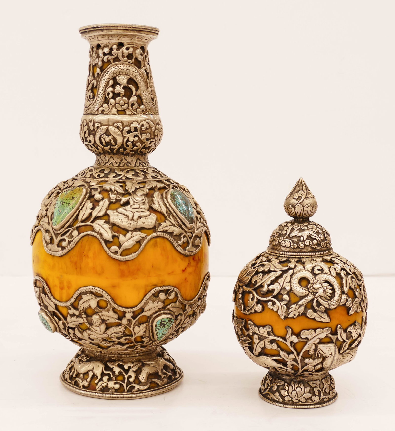 2pc Tibetan Buddhist Silver Vase and Jar 7.5'' to: 2pc Tibetan Buddhist Silver Vase and Jar 7.5'' to 12.5'' Tall. Heavy repousse silver work over a resin material with dragons and immortals. Applied turquoise stones on vase. Overall excellent conditio