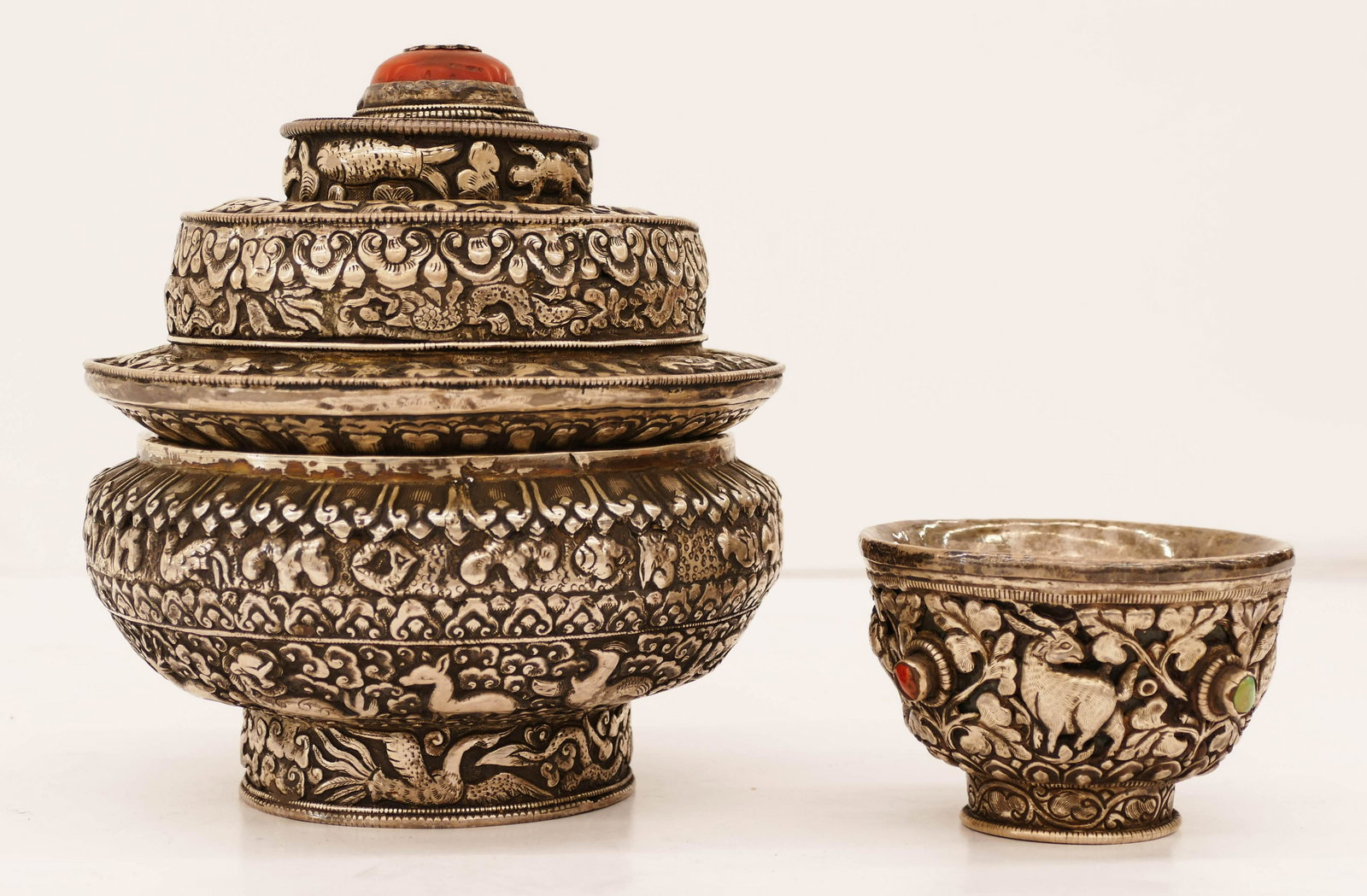 2pc Tibetan Buddhist Silver Offering Jar and Cup 2.5'': 2pc Tibetan Buddhist Silver Offering Jar and Cup 2.5'' to 7'' Tall. Heavy repousse silver over wood with animal and dragon motifs. Interior of jar has deep relief dragon motifs on top and bottom. Appl