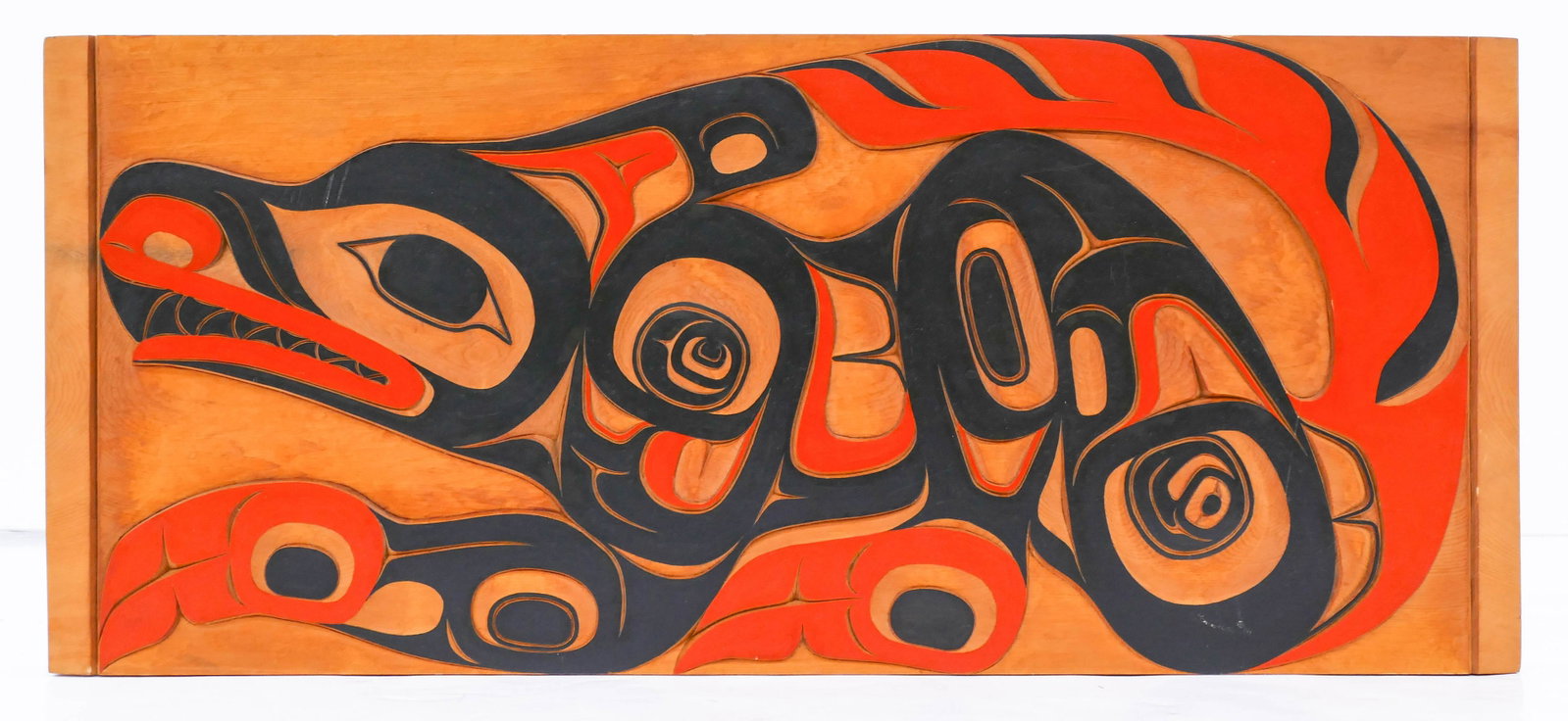 Kenny McNeil (b.1961 Tahltan Tlingit Nisga'a) Wolf: Kenny McNeil (b.1961 Tahltan Tlingit Nisga'a) Wolf Plaque 1989 Painted Cedar 11''x26''. A relief carved and painted u-form cedar horizontal plaque. Signed and dated on verso. A few small scattered scr
