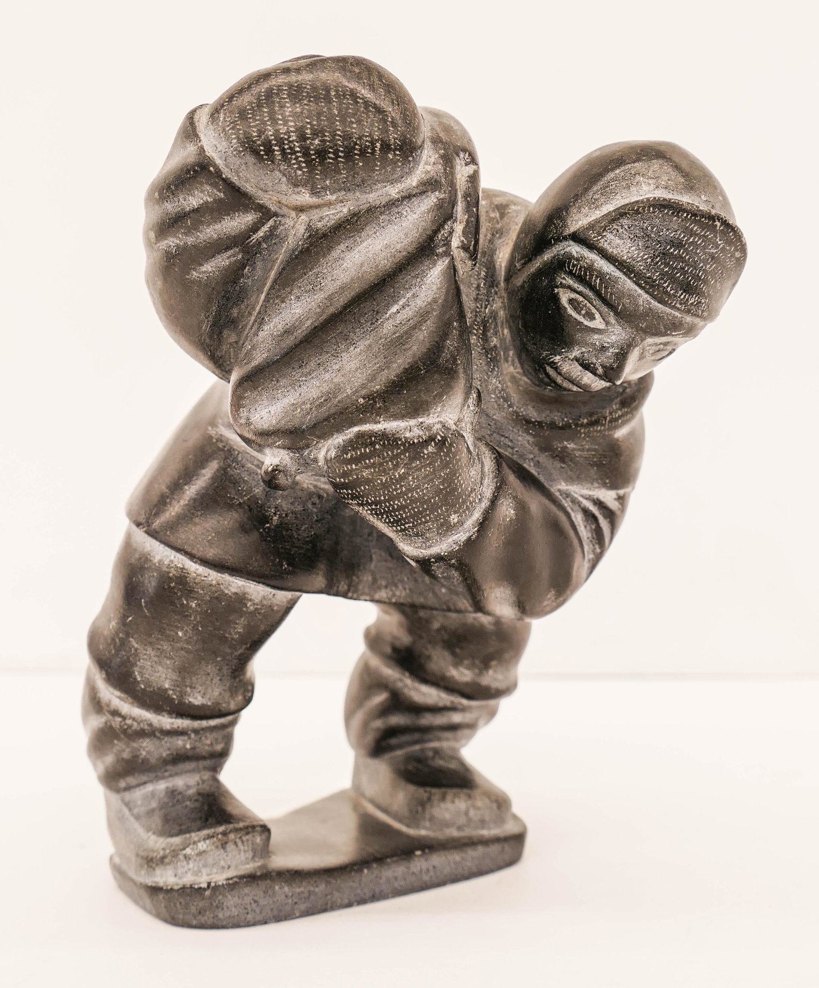 Makusi Anauta (b.1939 Inuit) Seal Hunter Soapstone: Makusi Anauta (b.1939 Inuit) Seal Hunter Soapstone Sculpture 7''x5''. A carved eskimo hunter with seal over shoulder. Signed on bottom. Overall excellent condition.