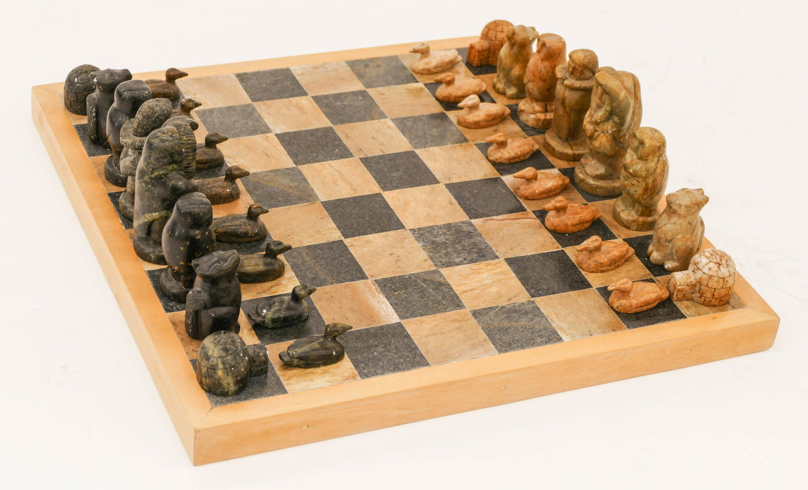 Fred Iyak (b.1961 Inuit) Eskimo Chess Set Carved: Fred Iyak (b.1961 Inuit) Eskimo Chess Set Carved Soapstone 5''x17''x17''. Impressive figural soapstone chess set with eskimo father and mother, owls, dogs, igloos, and loons. Signed on bottom of chess