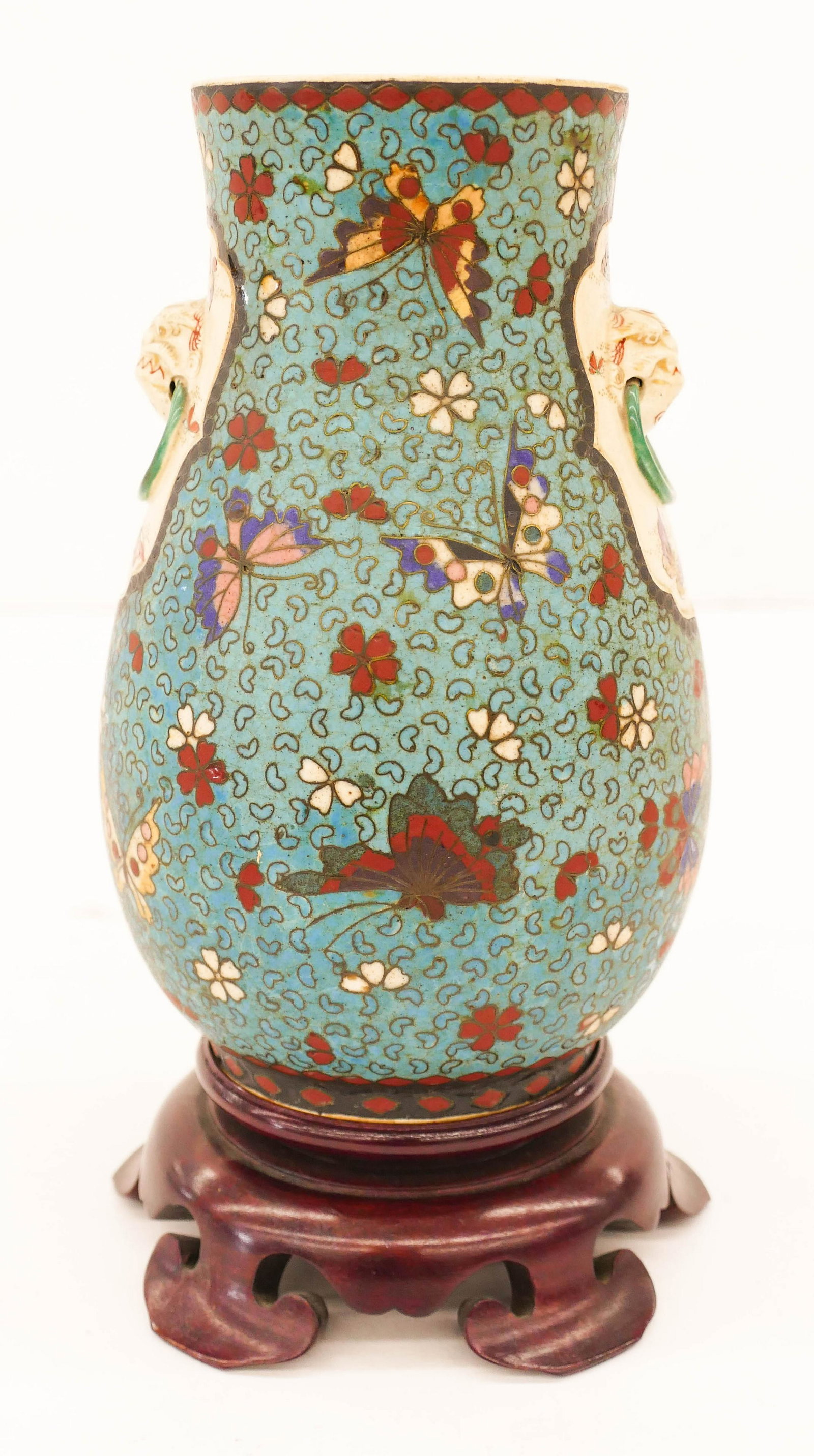 Japanese Meiji Totai Shippo Butterfly Handled Vase: Japanese Meiji Totai Shippo Butterfly Handled Vase 7.5''x4.5''. Unusual cloisonne over satsuma vase with molded foo dog ring handles. Unmarked. Comes with a fitted wood stand. Excellent condition. Est