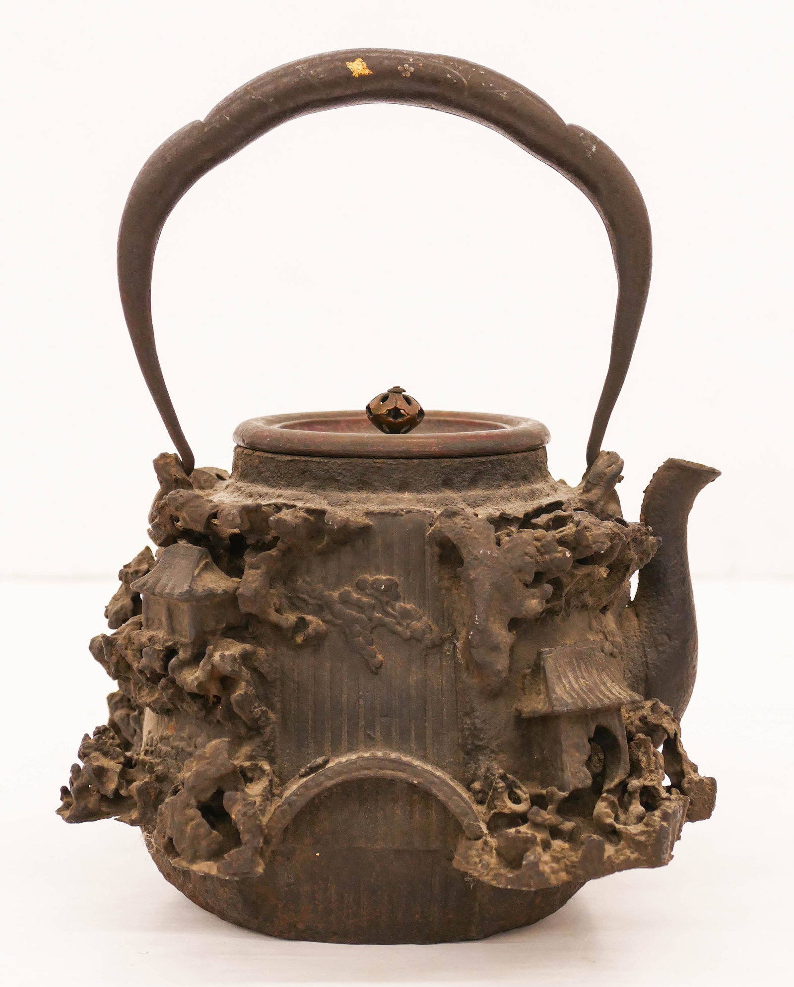 Kinryudo Japanese Decorated Cast Iron Tetsubin Kettle: Kinryudo Japanese Decorated Cast Iron Tetsubin Kettle 9.5''x7''. Impressive relief decorated kettle with iron temple landscape and bridge. Slight gold and silver inlay on bail. Signed under bronze lid