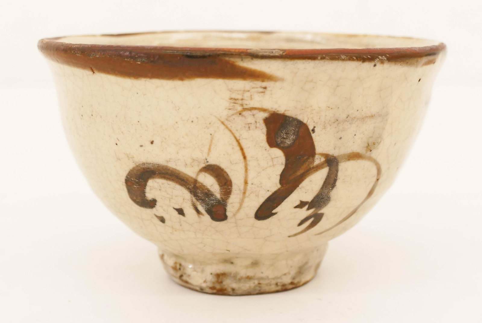 Korean Joseon Iron Brown Chawan Tea Bowl 3''x5.25'': Korean Joseon Iron Brown Chawan Tea Bowl 3''x5.25''. White ceramic bowl with iron brown scrolling motif and rim. Some slight glaze flaking to top rim. 15th or 16th century. Collection of W. Gordon Men
