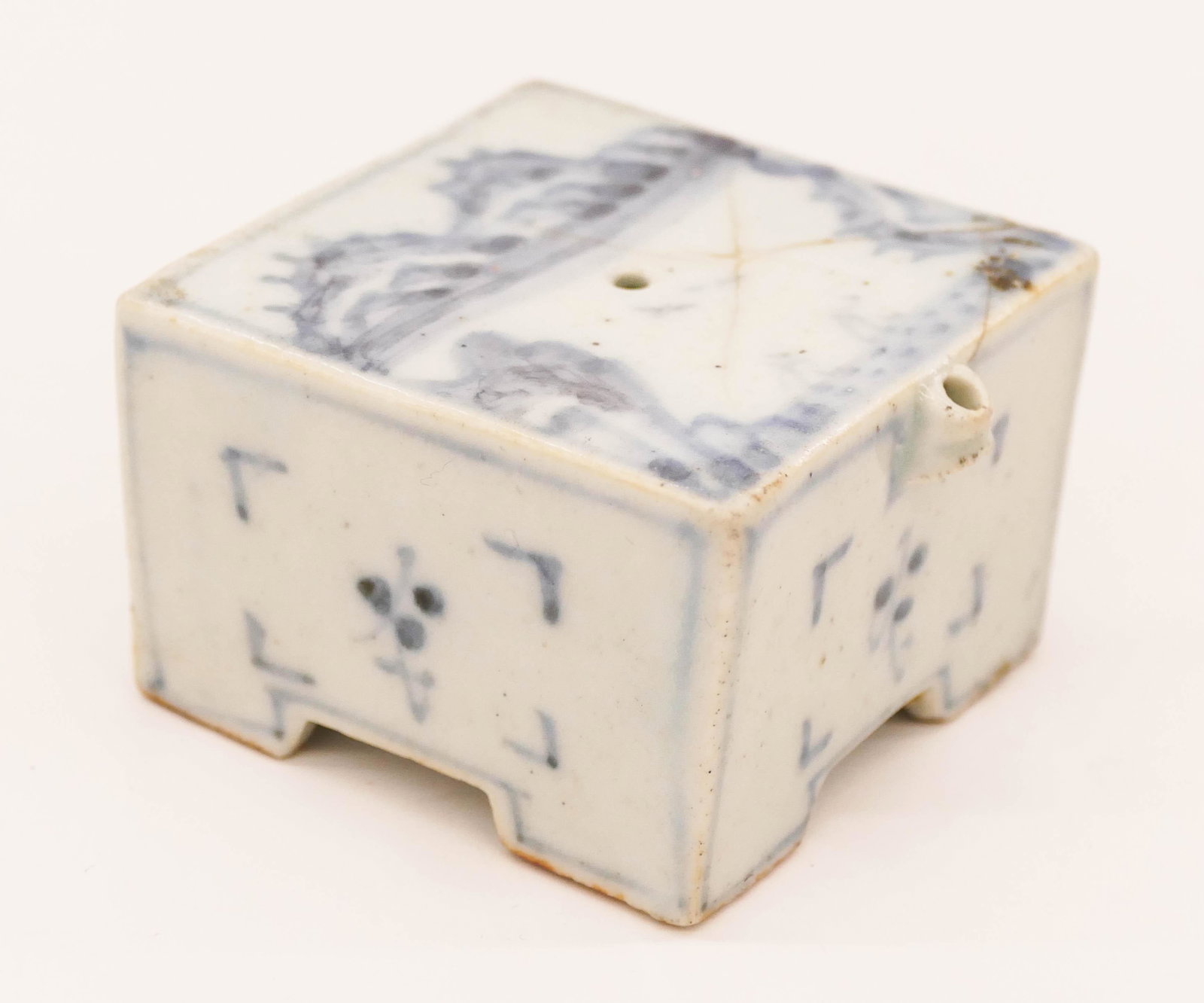 Korean Joseon Blue and White Square Water Dropper: Korean Joseon Blue and White Square Water Dropper 1.5''x2.5''. Blue underglaze decorated porcelain with landscape motif. Impact crack to top panel that extends to side. 18th or 19th century. Collectio