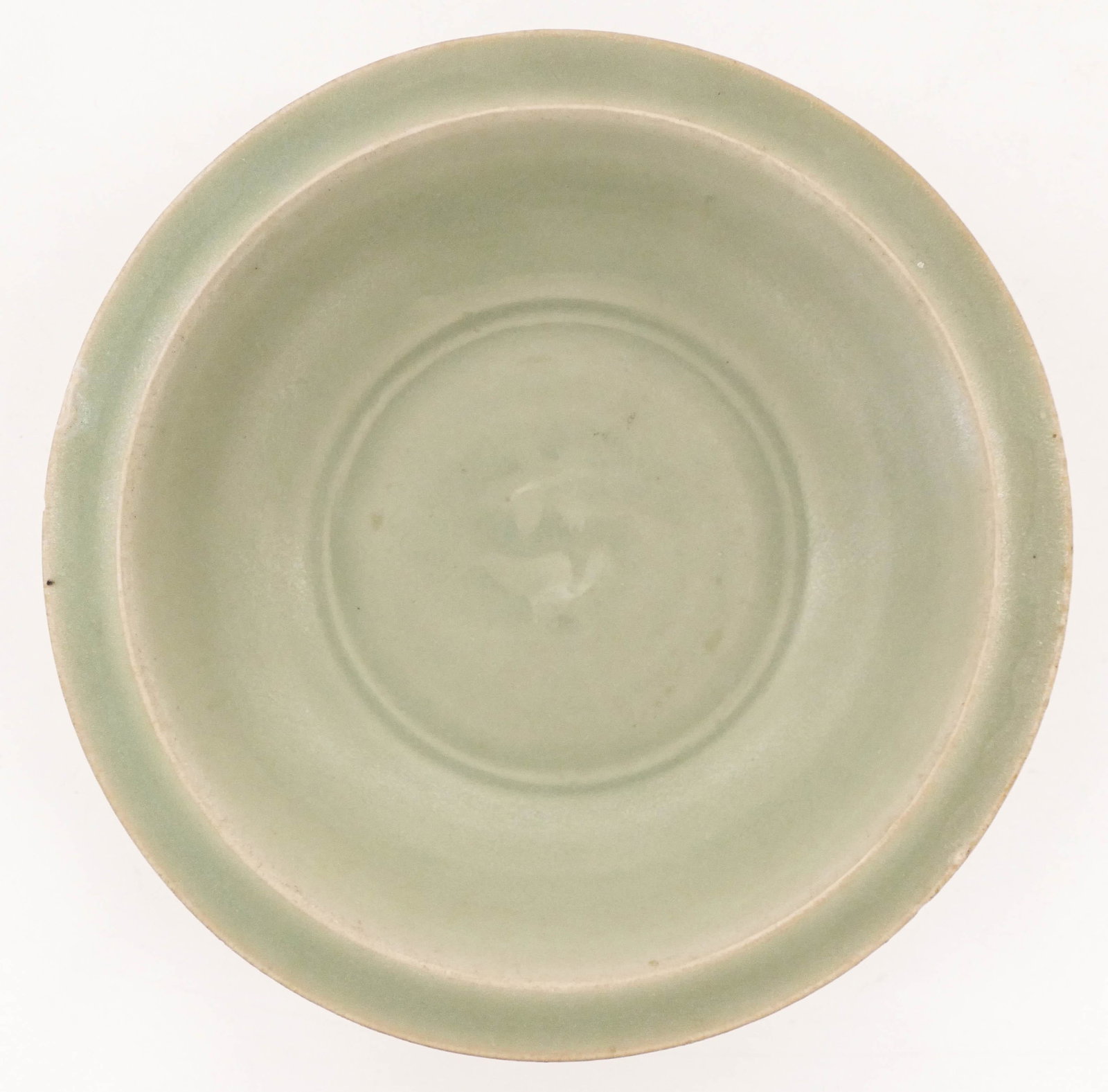 Chinese Yuan Longquan Twin Fish Low Bowl 1.5''x7.75": Chinese Yuan Longquan Twin Fish Low Bowl 1.5''x7.75''. A celadon glazed ceramic bowl with twin fish central motif. A few small glaze flakes to rim. 13th or 14th century. Collection of W. Gordon Menzie
