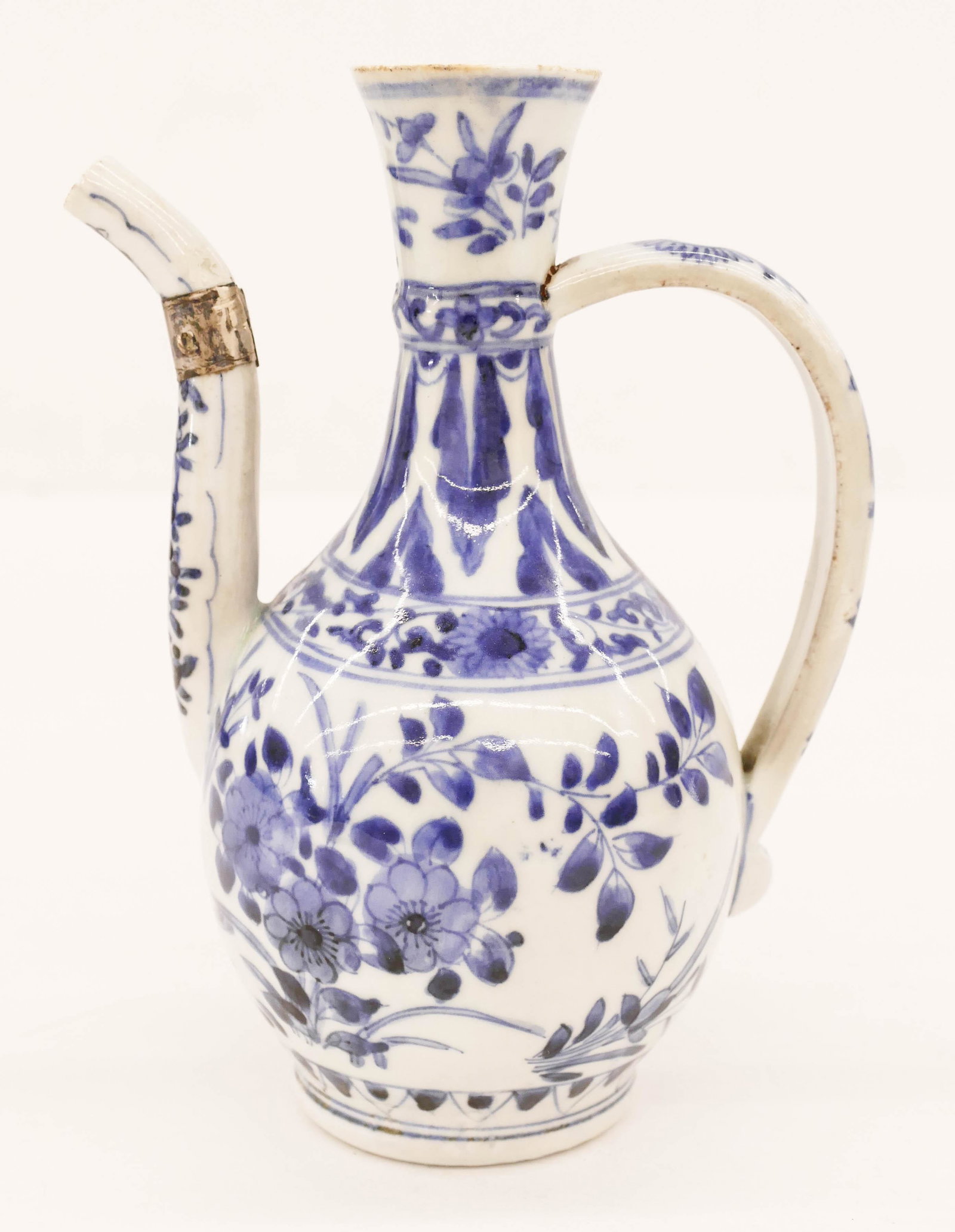 Japanese 17th Cent. Arita Wine Ewer 7.25''x5.5'': Japanese 17th Cent. Arita Wine Ewer 7.25''x5.5''. A blue and white porcelain kendi-like ewer with floral motifs. Spout is repaired with silver fitted. Edo period. Collection of W. Gordon Menzies, Seat