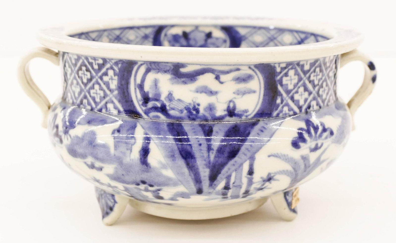 Japanese 18th Cent. Arita Tripod Censer 4.25''x8.25": Japanese 18th Cent. Arita Tripod Censer 4.25''x8.25''. A blue and white porcelain handled koro with landscape motifs. Some slight glaze roughness to one handle. Edo period. Collection of W. Gordon Men