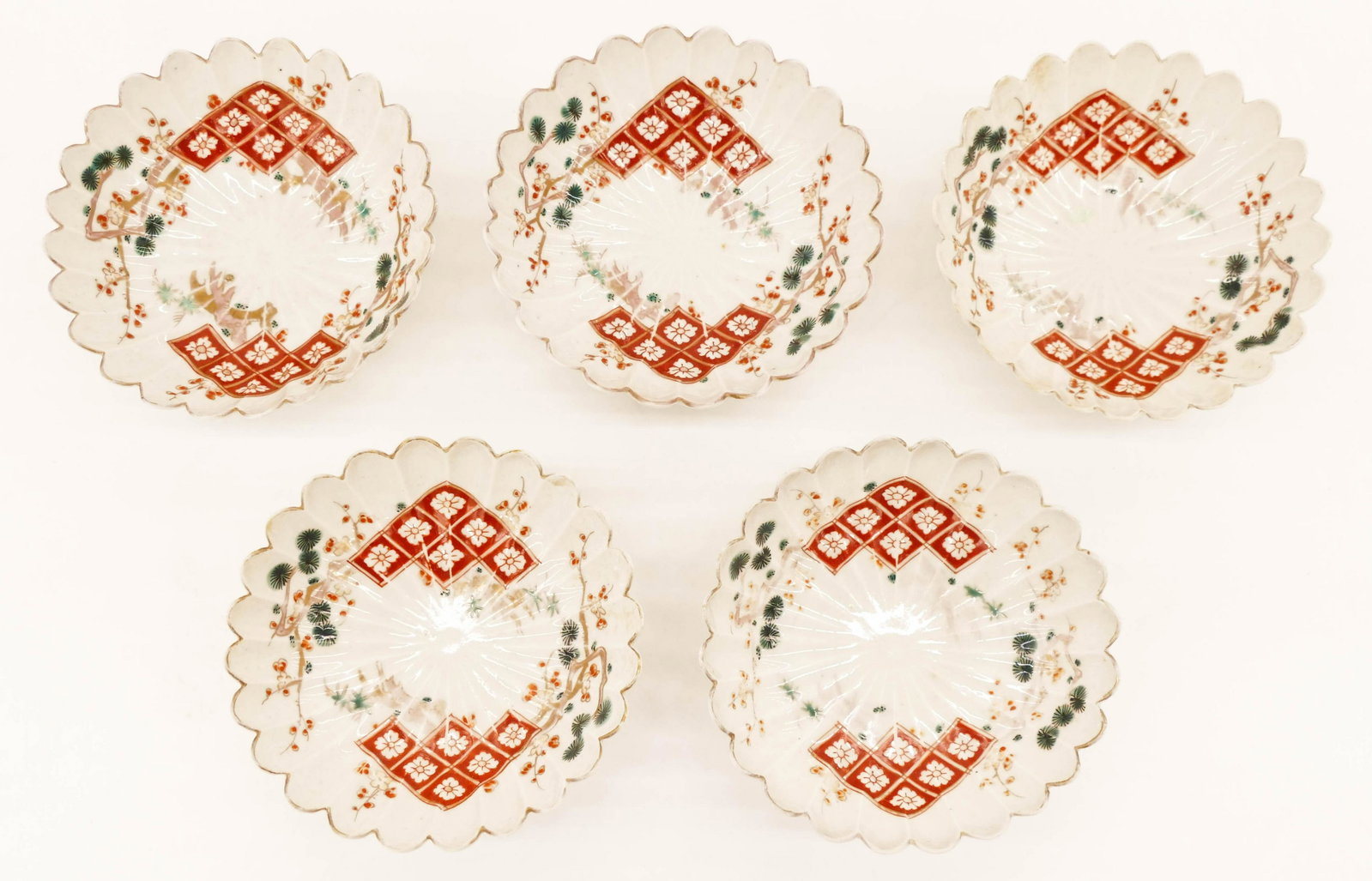 5pc Japanese Edo Kutani Scalloped Dishes 1.5''x5.25": 5pc Japanese Edo Kutani Scalloped Dishes 1.5''x5.25''. A group of five polychrome enameled porcelain dishes with pine branch motif. One has slight edge flake. Wear to gilt edges. Early 19th century. C