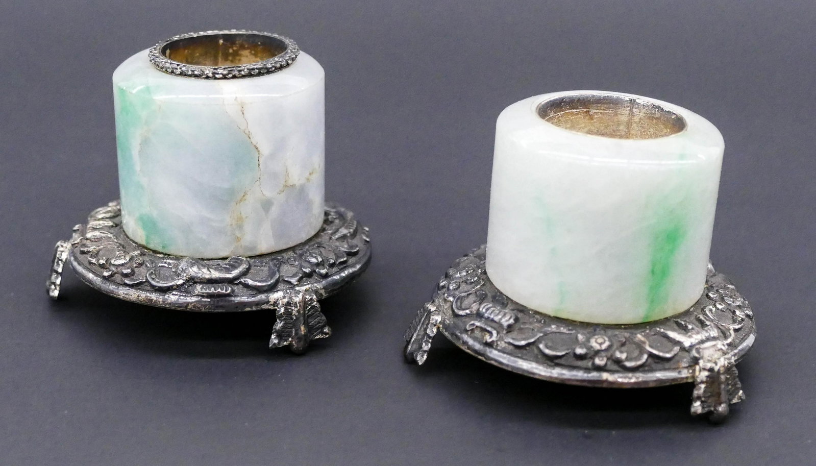 Pair Chinese Qing Jadeite Archer's Ring Silver Salts: Pair Chinese Qing Jadeite Archer's Ring Silver Salts 1.5''x2''. A duo of grey to white to apple green jade archer rings repurposed into silver mounted salts. Some natural cracking lines in jade. 18th 