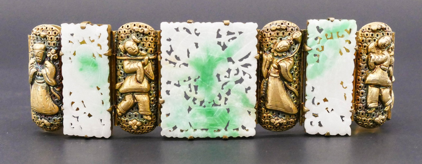 Old Chinese Pierced Jadeite Gilt Silver Bracelet 7": Old Chinese Pierced Jadeite Gilt Silver Bracelet 7''x1.5''. Gilt silver bracelet with relief immortals includes three pierced white to apple green jade panels measuring 36x30mm and 36x15mm. Marked ''S