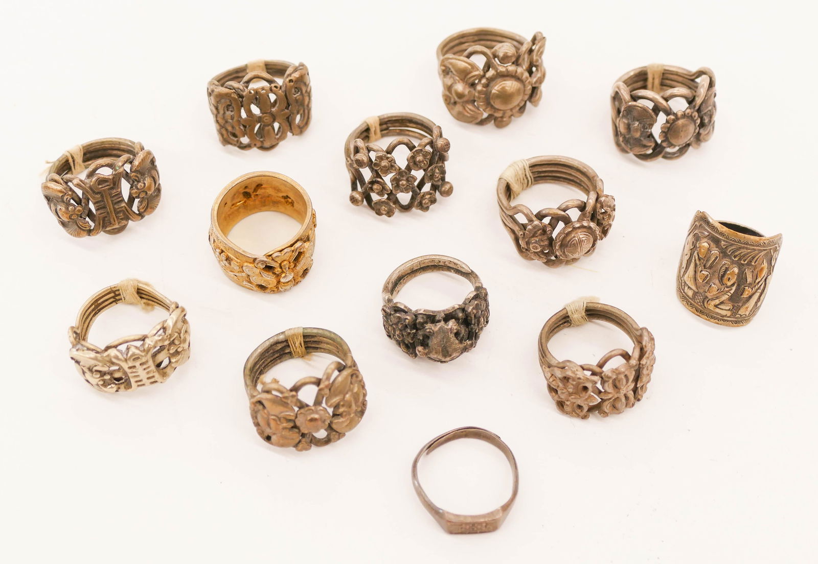 13pc Chinese Qing Silver Rings.: 13pc Chinese Qing Silver Rings. Includes various filigree decorated rings with shou symbols, flowers, figures, and bats. Group weighs 97.4 grams total. Some surface wear from use. 19th century. Collec