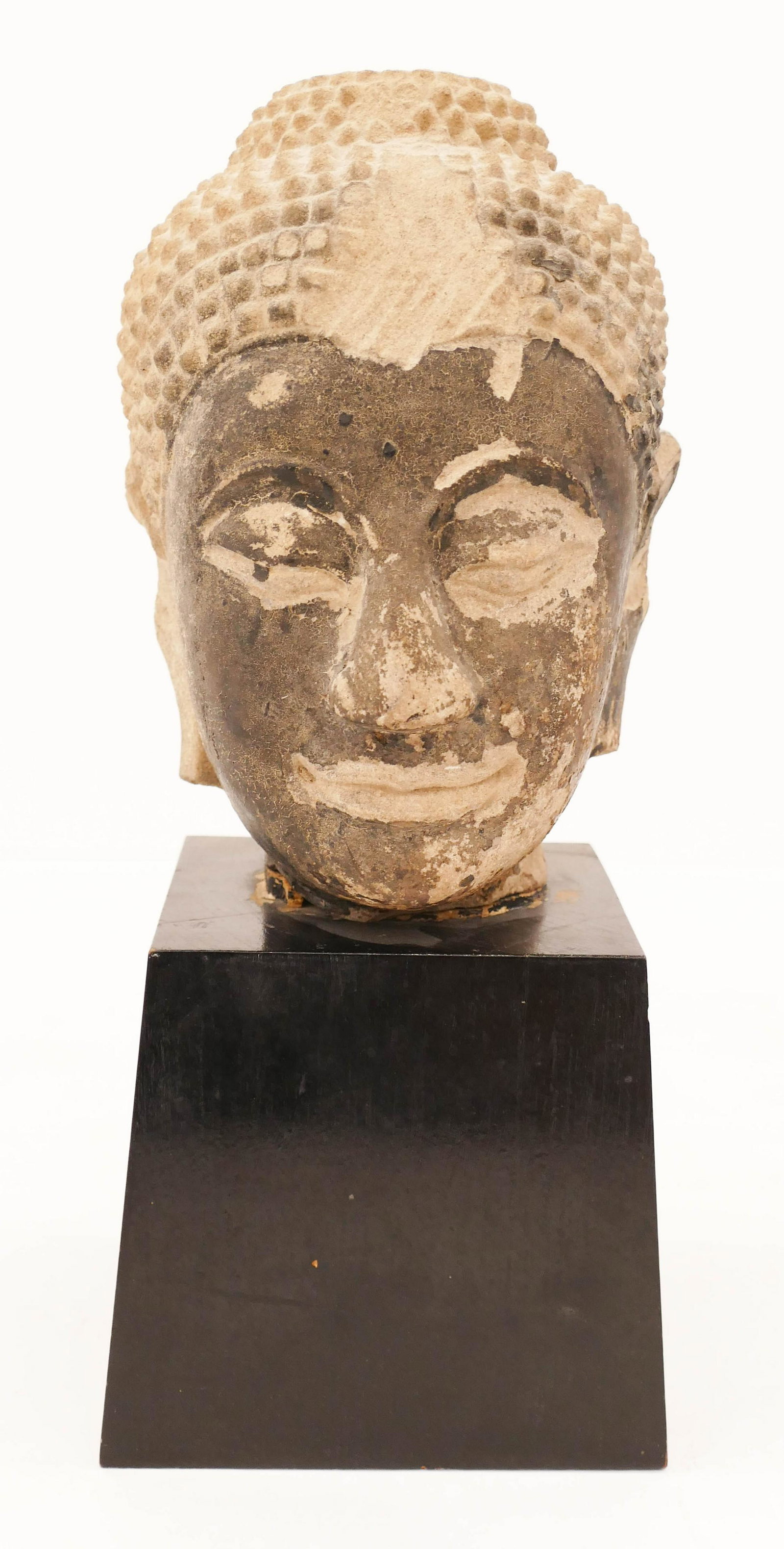 Thai 15th/16th Sandstone Buddha Head on Stand: Thai 15th/16th Sandstone Buddha Head on Stand 14.5''x6''. A carved stone head that looks to have been darkened by a fire. Head measures 9'' long. Scattered surface wear and loss from age. From a priva