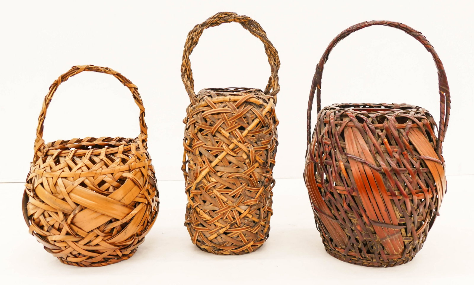 3pc Old Japanese Ikebana Handled Baskets 14'' to 18": 3pc Old Japanese Ikebana Handled Baskets 14'' to 18'' Tall. A trio of hand made flower arranging baskets. The darker one is singed on bottom. Excellent condition. Early to mid 20th century, Meiji to S