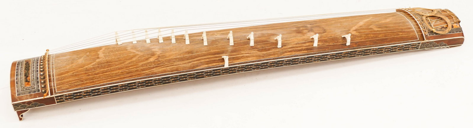 Fine Japanese Meiji Inlaid Koto Harp Instrument: Fine Japanese Meiji Inlaid Koto Harp Instrument 75''x8''x10.5''. Removed from the Takarazuka Theatre in Japan during WWII. Finely inlaid with arrow and cloud motifs on side. Gilt bronze dragon ornamen