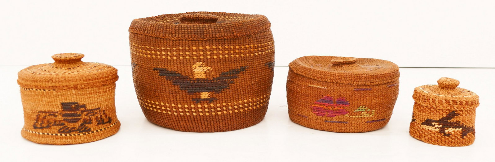 4pc Old Tsimshian Pictorial Covered Indian Baskets: 4pc Old Tsimshian Pictorial Covered Indian Baskets 3''x3'' to 6''x7''. Includes a large eagle motif basket, a medium rose motif, a smaller eagle, and a small killer whale. Overall excellent condition.