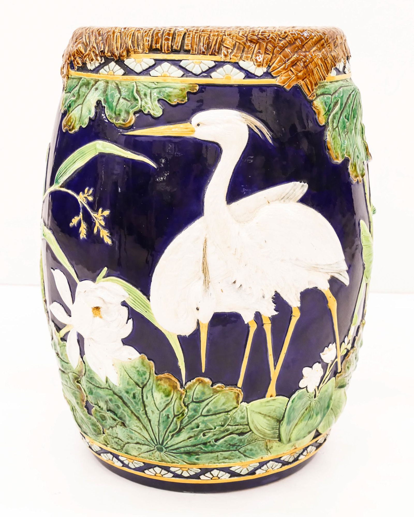 George Jones Majolica Stork and Swallow Garden Seat: George Jones Majolica Stork and Swallow Garden Seat 18.5''x13''. A scarce japonisme drum form garden stool with relief bird and lotus flower motifs. Unmarked. Some glaze rubbing to top and a few small