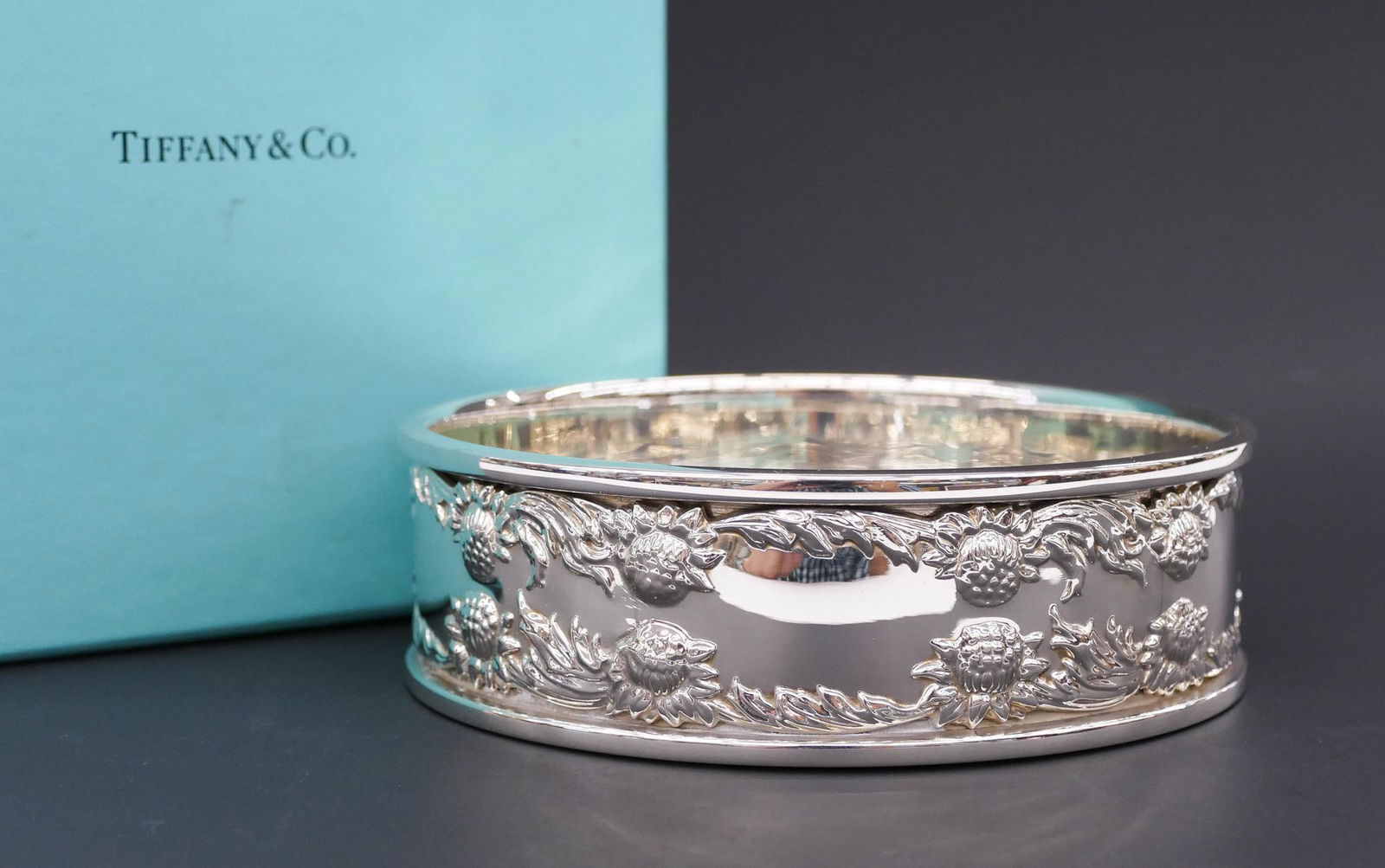 Tiffany & Co. ''Chrysanthemum'' Sterling Wine Coaster: Tiffany & Co. ''Chrysanthemum'' Sterling Wine Coaster 1.75''x5''. A heavy sterling wine or champagne coaster with floral edges. Marked with form 26096. Like new condition with no monogram. Comes with