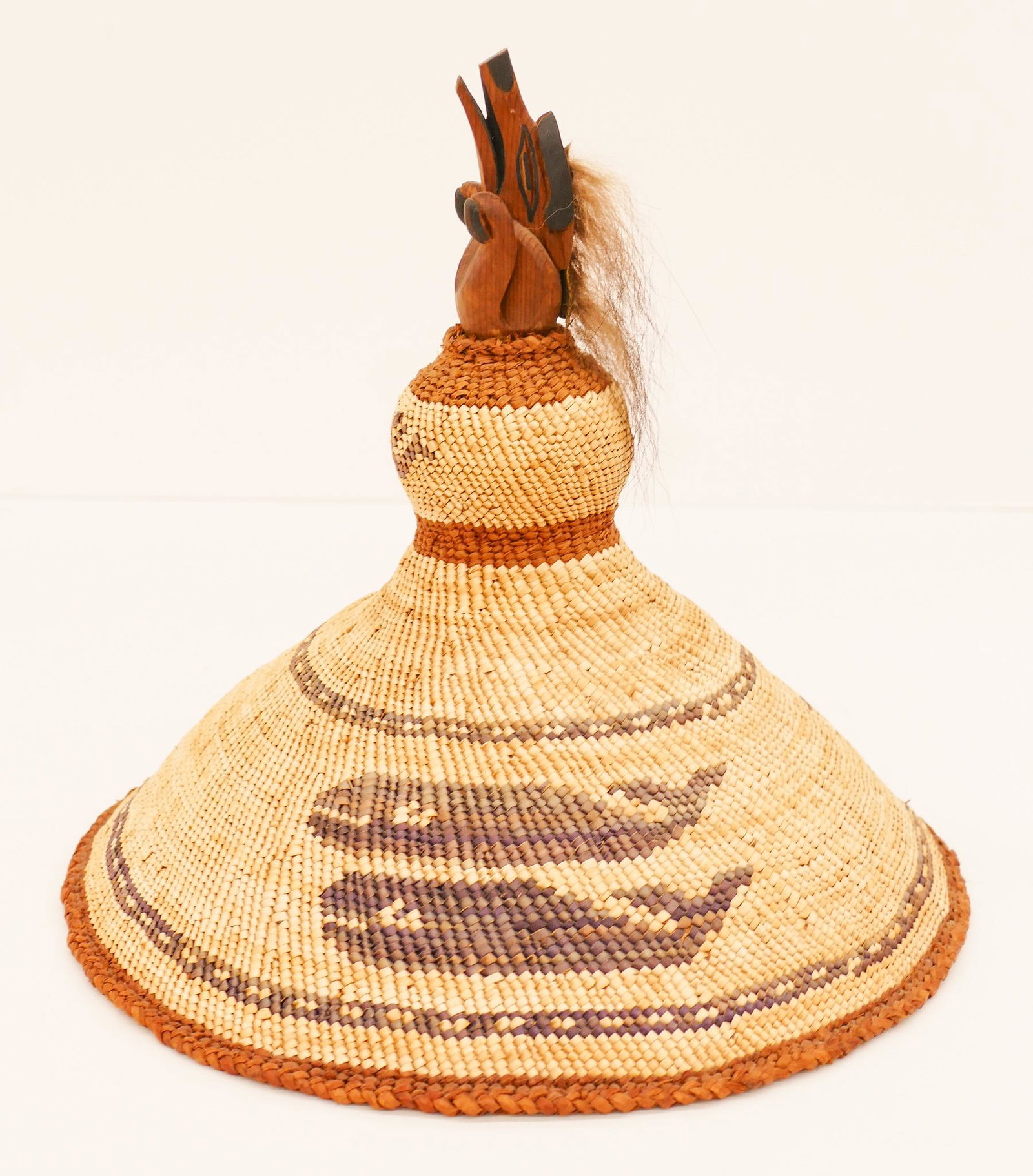 Greg and Linda Colfax Maquinna Whaler's Hat: Greg and Linda Colfax (20/21st Cent. Makah) Maquinna Whaler's Hat 9.5''x10.5''. A hand woven cedar bark Indian basketry hat with carved cedar wolf finial. Whaling canoes and twin whale motifs. Unsigne