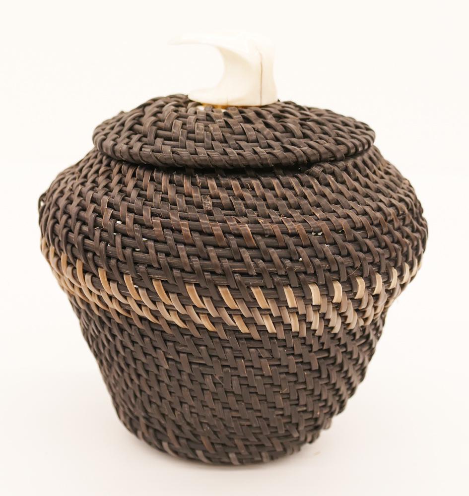 James Omnik Jr. Whale Tail Large Baleen Basket: James Omnik Jr. (20th Cent. Inuit) Whale Tail Large Baleen Basket 5.5''x5.25''. A finely woven native covered two-tone baleen basket with whale tail finial. Incised mark on bottom. Excellent condition