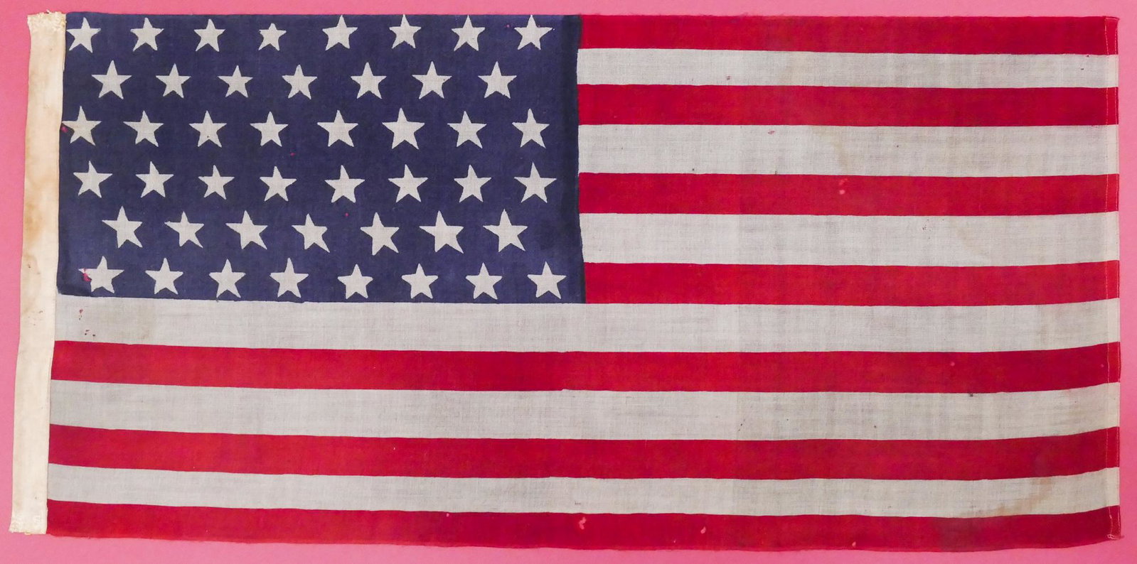 Antique 46 Star American Flag: Antique 46 Star American Flag. Framed. Flag measures 17.5x37''. Flag is glue down to red mat board and framed. Overall frame measurements are 41x21.5''. Flag has small moth holes throughout and some s