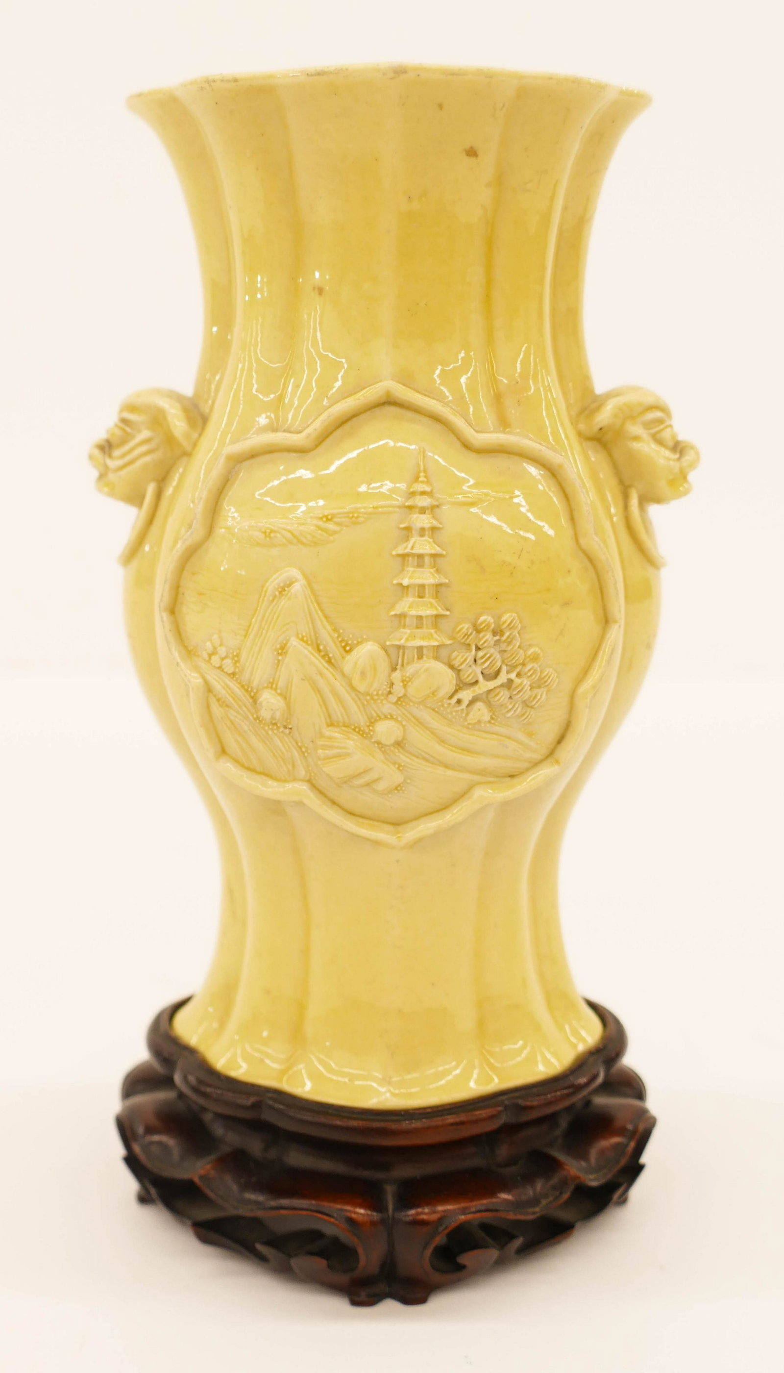 Chinese Bingrong Wang Yellow Vase: Chinese Bingrong Wang Yellow Vase 5.75''x3.5''. A fine yellow monochrome carved and applied porcelain quatrefoil vase with figural foo lion head handles. Landscape medallions with pagoda and huts. Fou