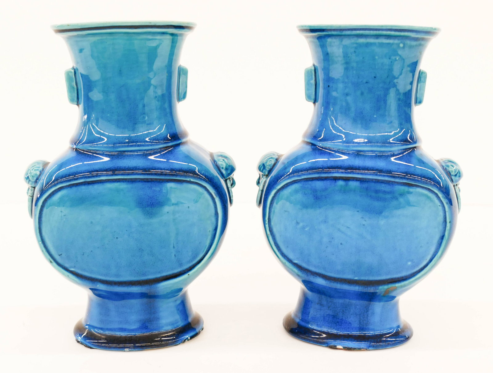 Pair Chinese Qing Peacock Blue Hu Vases: Pair Chinese Qing Peacock Blue Hu Vases 8.5''x6''. Deep blue glazes with molded head and ring handles. Unmarked. Kiln chipping to bases, original to their manufacture. 19th century, Qing dynasty.