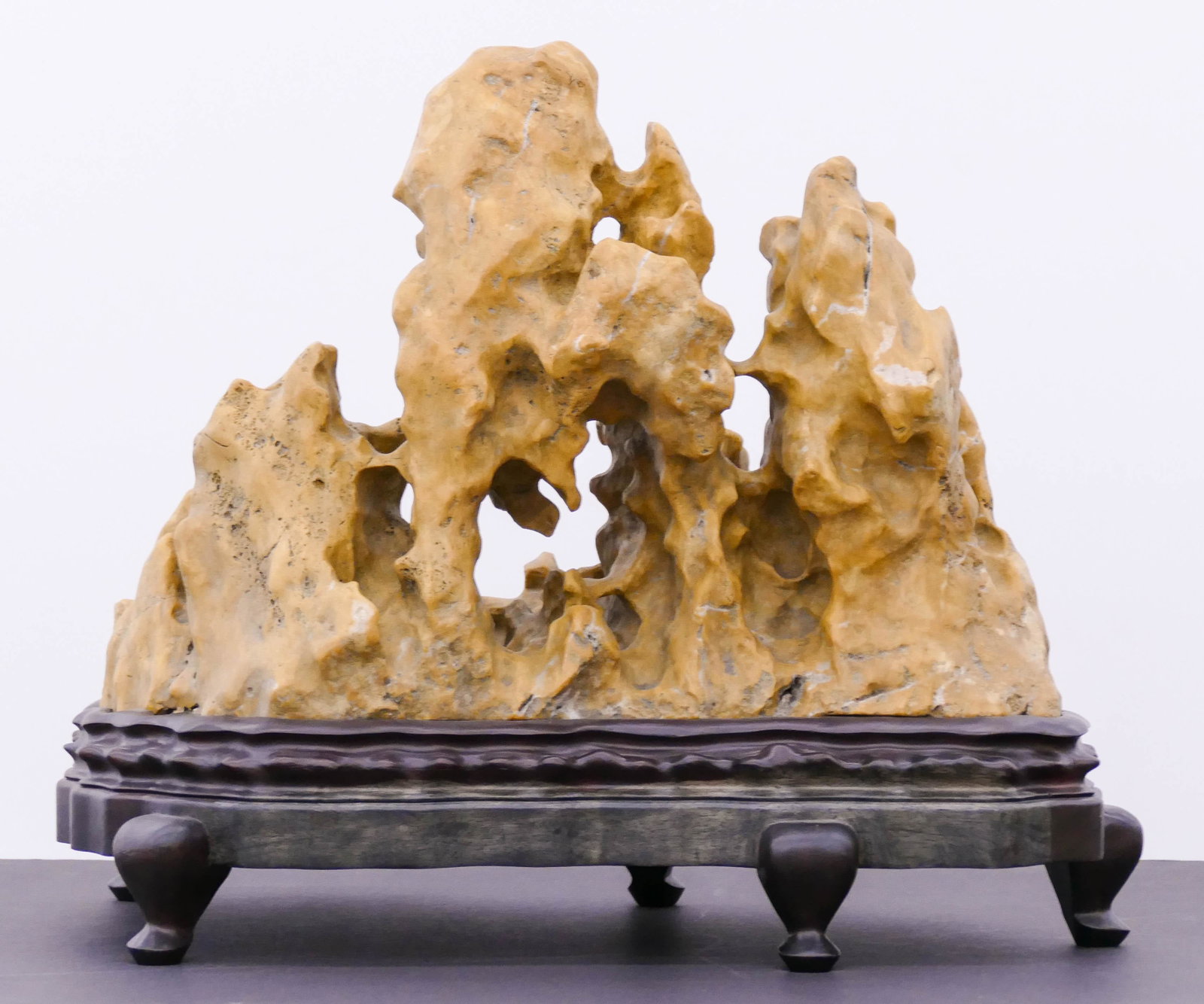 Chinese Mountain Scholar's Rock on Stand: Chinese Mountain Scholar's Rock on Stand 22''x18''x13''. Impressive yellow stone mountainous rock formation on fitted wood stand. It weighs 50+ pounds. Excellent condition. 20th century.